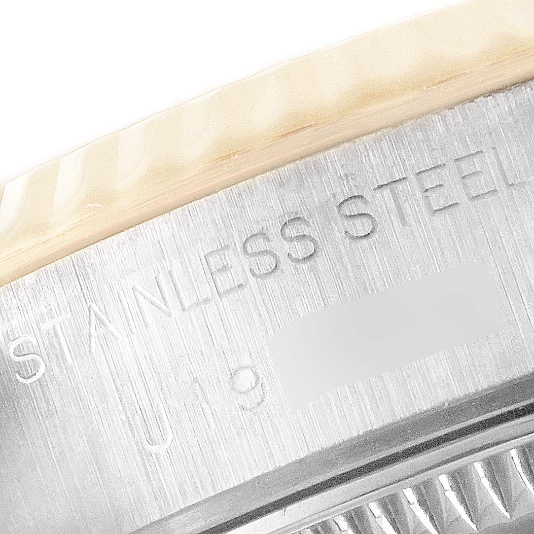 The image shows a close-up view of the side of a Rolex Datejust 69173 Women
s Steel and Gold (two tone) Champagne Dial 69173 Women
s Steel and Gold (two tone) Champagne Dial watch, highlighting the "STAINLESS STEEL" engraving.