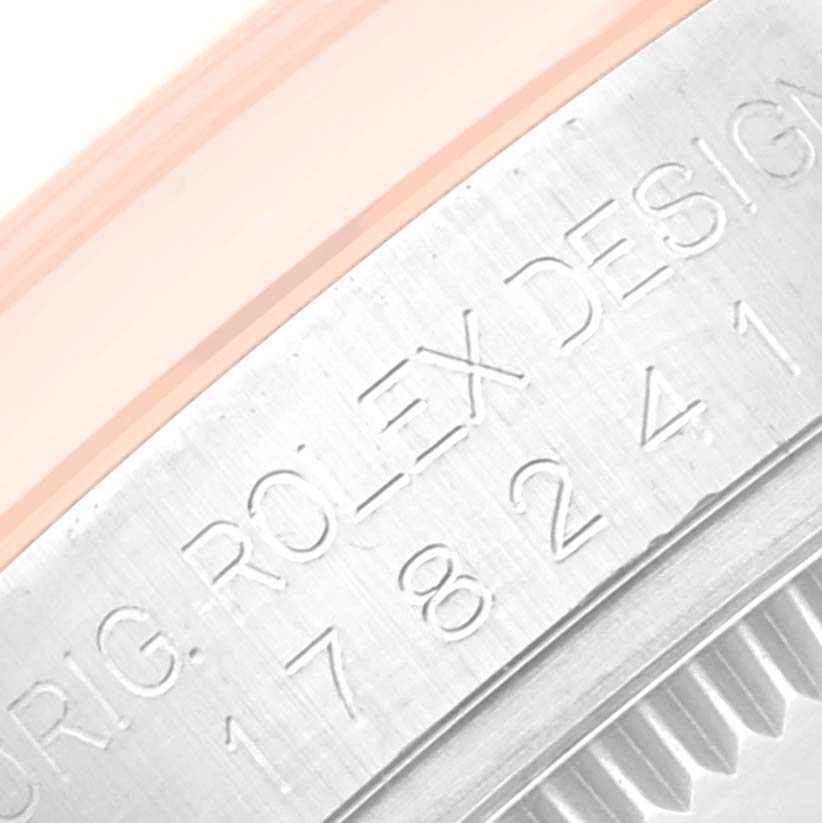 This close-up image of a Mid-Size Rolex watch shows an engraved section of the case back and part of the bezel.