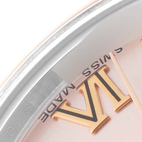 This close-up image of the Mid-Size Rolex watch shows part of the bezel, dial, and Roman numeral hour marker.