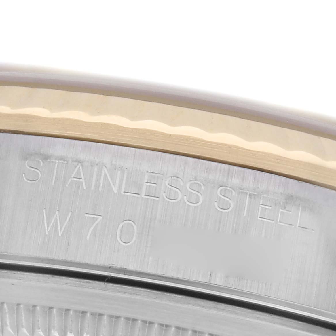The image shows an angled close-up of a Rolex Datejust 16233 Men's Steel and Gold (two tone) Champagne Dial 16233 Men's Steel and Gold (two tone) Champagne Dial case back with "STAINLESS STEEL" engraving.