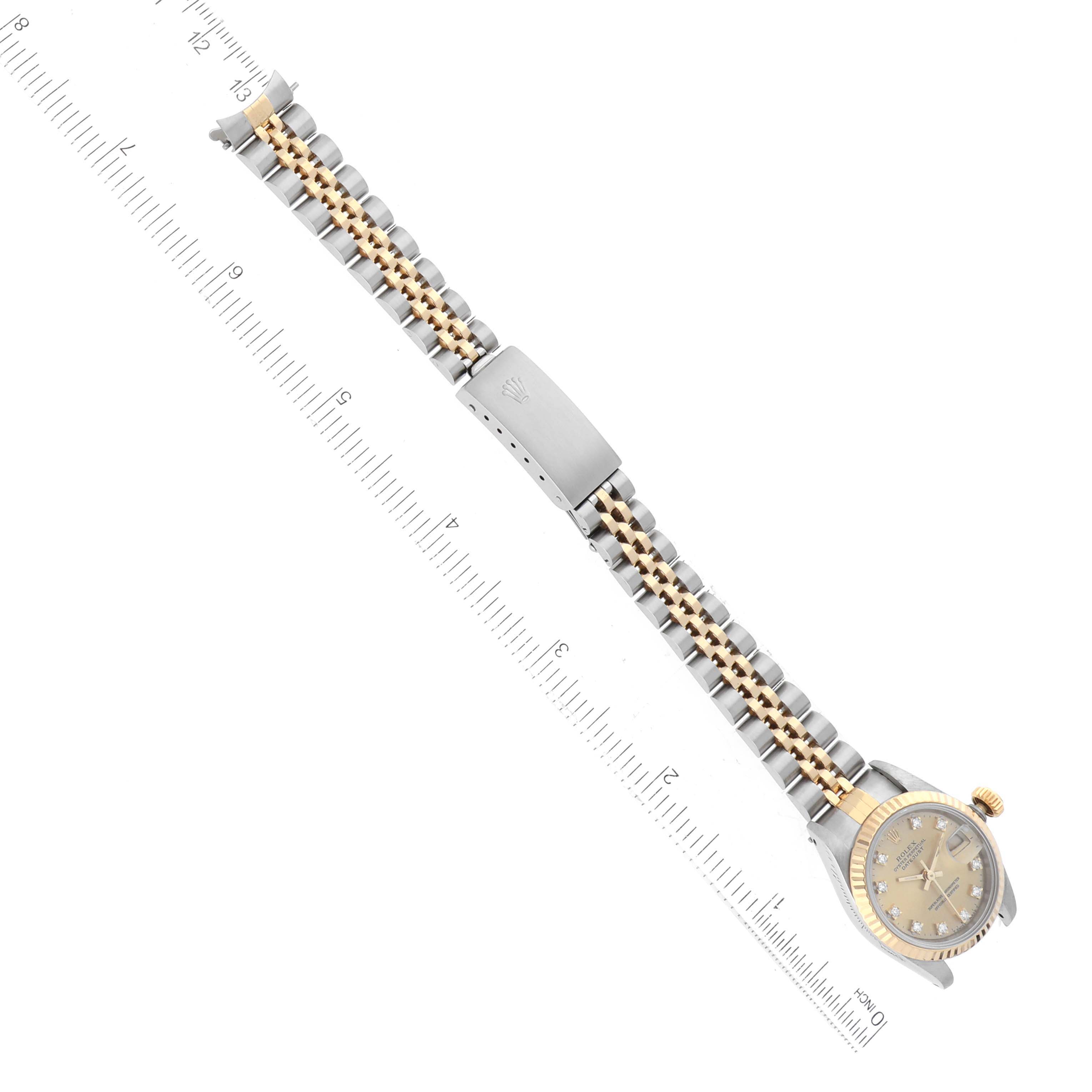 This image shows the Rolex Datejust 69173 Women's Steel and Gold (two tone) Champagne Dial 69173 Women's Steel and Gold (two tone) Champagne Dial watch laid flat with an emphasis on the bracelet and clasp alongside a ruler.