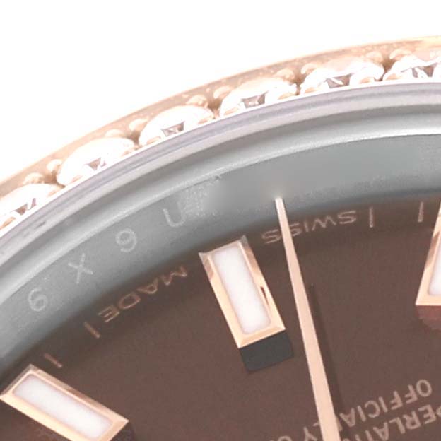 This close-up of the Rolex Datejust 279381 Women's Steel and Gold (two tone) Brown Dial 279381 Women's Steel and Gold (two tone) Brown Dial watch shows part of the dial with hour markers and a diamond-studded bezel.