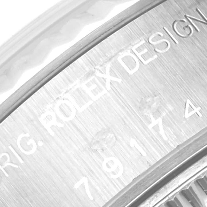 Close-up of the edge of a Rolex Datejust 79174 Women's Stainless Steel Blue Dial 79174 Women's Stainless Steel Blue Dial, showing part of the engraved model number and "ROLEX DESIGN" text.