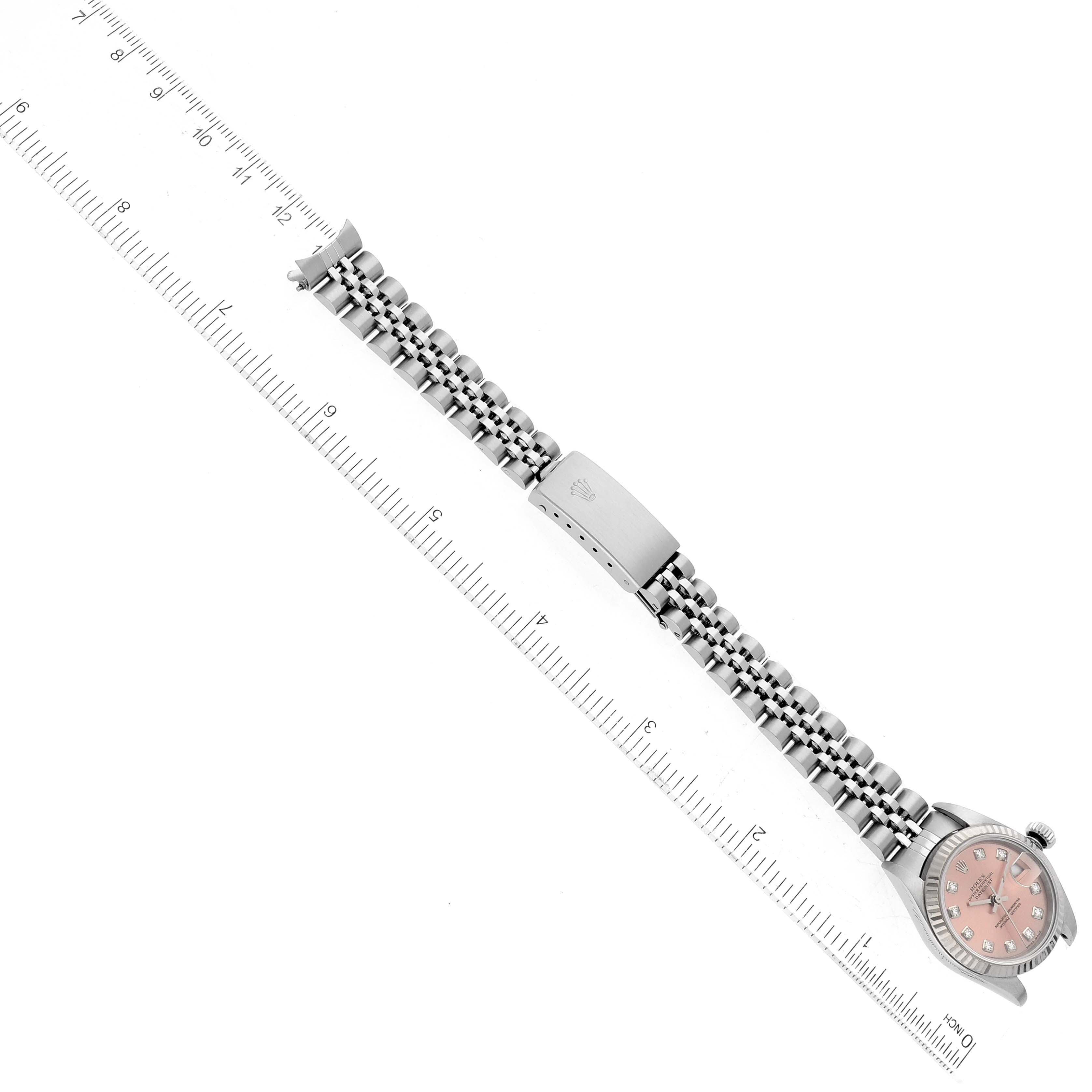 The image shows the entire Rolex Datejust 79174 Women's Stainless Steel Pink Dial 79174 Women's Stainless Steel Pink Dial model watch, laid flat next to a ruler, displaying the strap, clasp, and watch face.