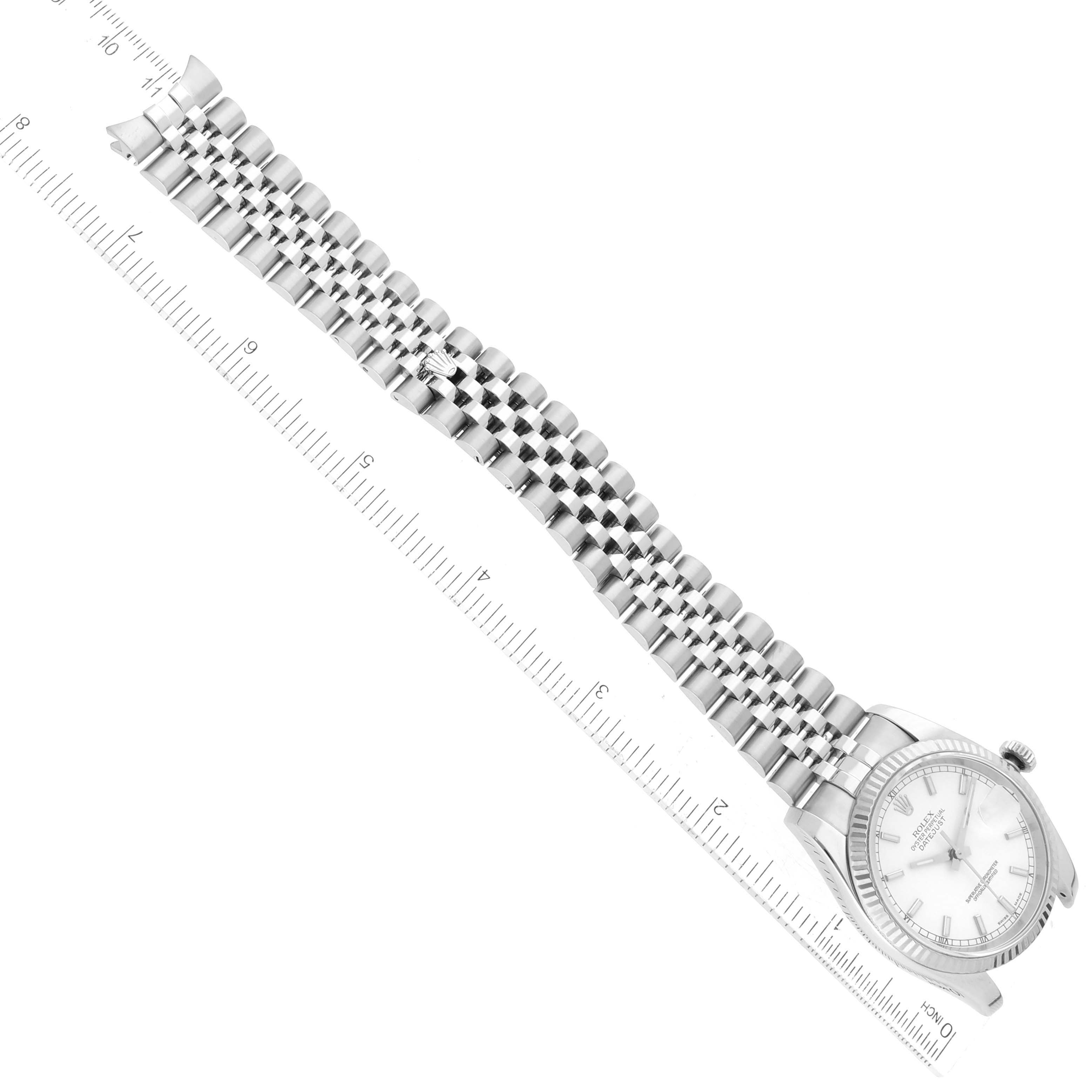The image shows a Rolex Datejust 116234 Men's Stainless Steel White Dial 116234 Men's Stainless Steel White Dial watch laid flat with its face and Jubilee bracelet fully extended alongside a ruler.