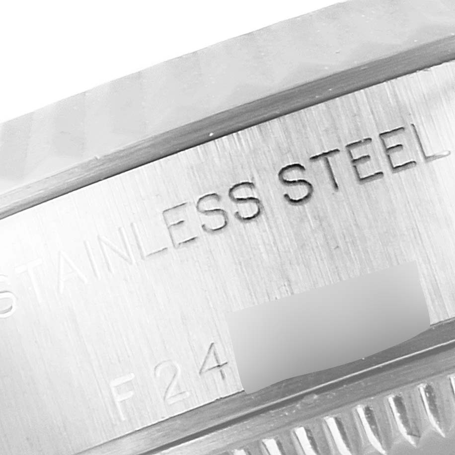 This close-up image of the Rolex Datejust 79174 Women
s Stainless Steel Mother of Pearl Dial 79174 Women
s Stainless Steel Mother of Pearl Dial watch shows a part of the stainless steel case with engraved details.