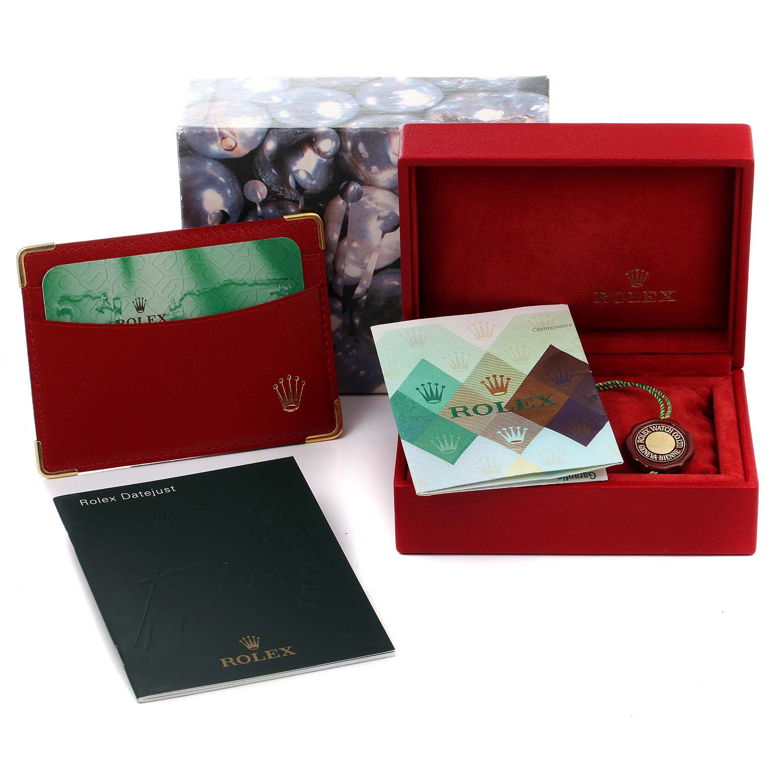The image shows the packaging and accessories for a Rolex Datejust 79174 Women
s Stainless Steel Mother of Pearl Dial 79174 Women
s Stainless Steel Mother of Pearl Dial watch, including a booklet, red box, certificate, and cardholder.