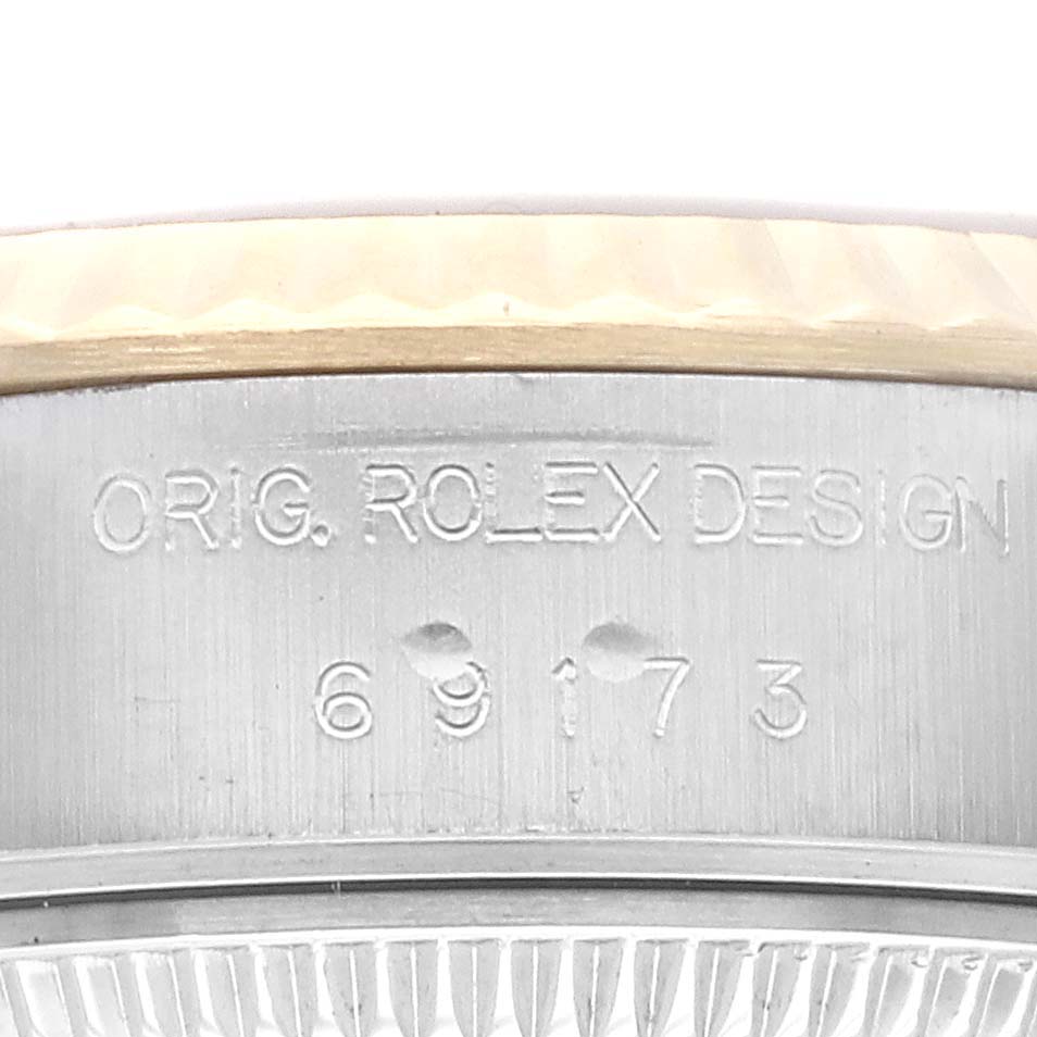 This close-up shows the side of the Rolex Datejust 69173 Women's Steel and Gold (two tone) Black Dial 69173 Women's Steel and Gold (two tone) Black Dial watch, featuring the engravings "ORIG. ROLEX DESIGN" and the model number.