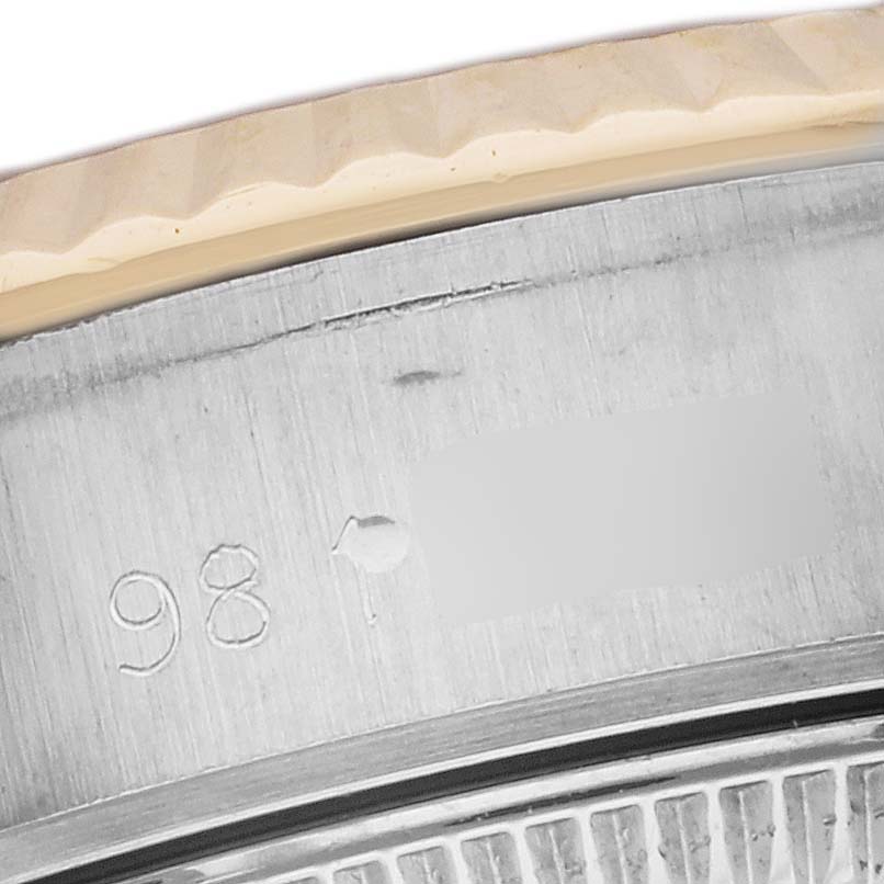 This close-up shows the engraved serial number and a portion of the fluted bezel of a Rolex Datejust 69173 Women's Steel and Gold (two tone) Black Dial 69173 Women's Steel and Gold (two tone) Black Dial watch.