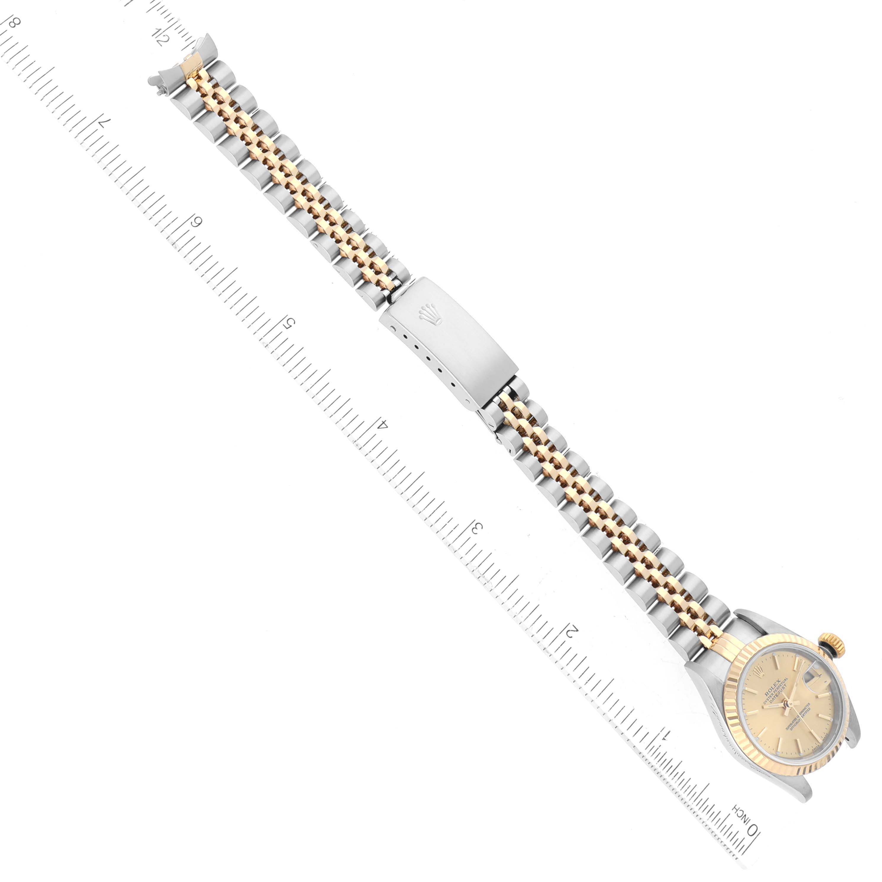 The image shows a Rolex Datejust 79173 Women's Steel and Gold (two tone) Champagne Dial 79173 Women's Steel and Gold (two tone) Champagne Dial watch from a top-down angle, displaying the entire band and face alongside a measuring ruler.