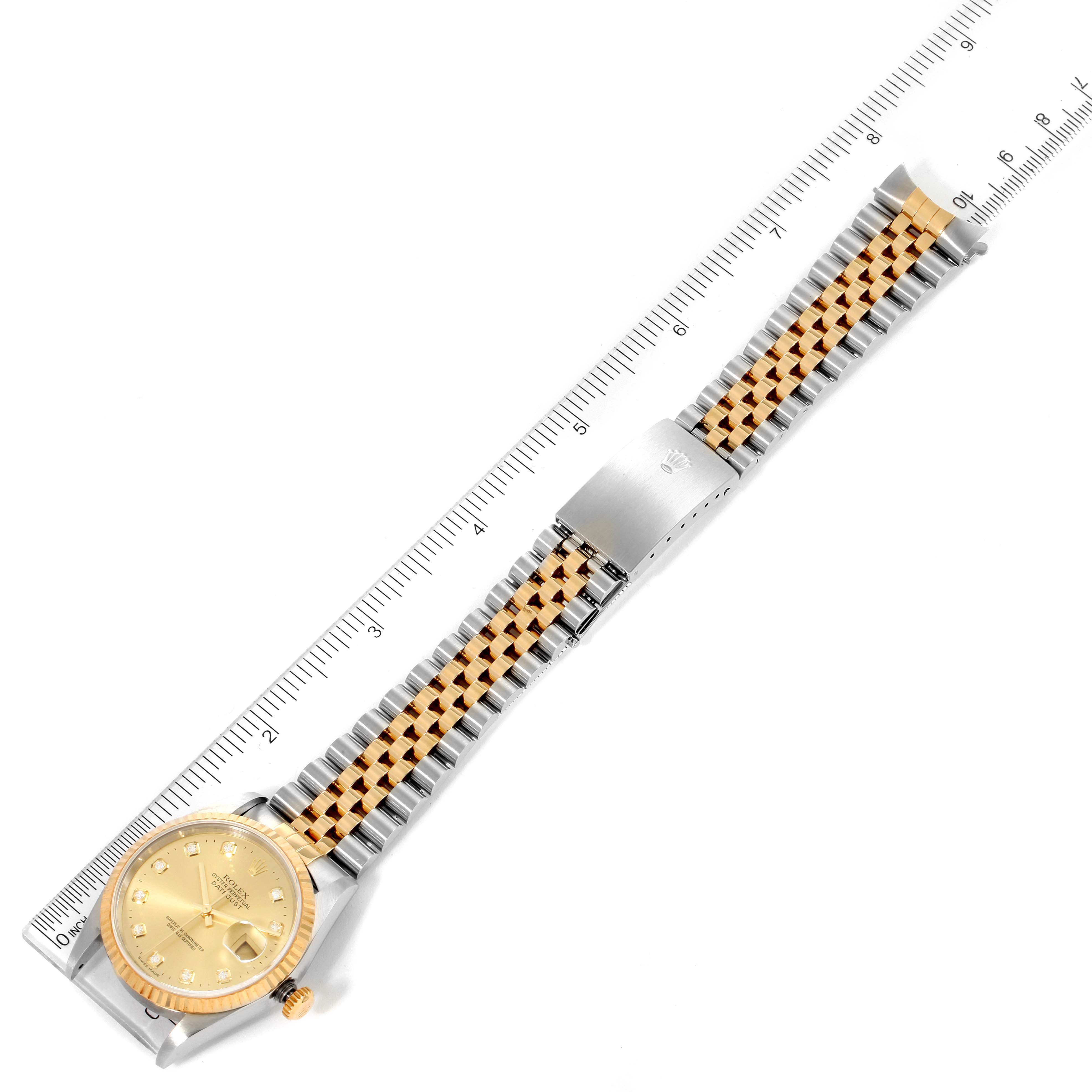 The Rolex Datejust 16233 Men's Steel and Gold (two tone) Champagne Dial 16233 Men's Steel and Gold (two tone) Champagne Dial watch is shown from a top-down angle, displaying its full strap and dial against a ruler for scale.