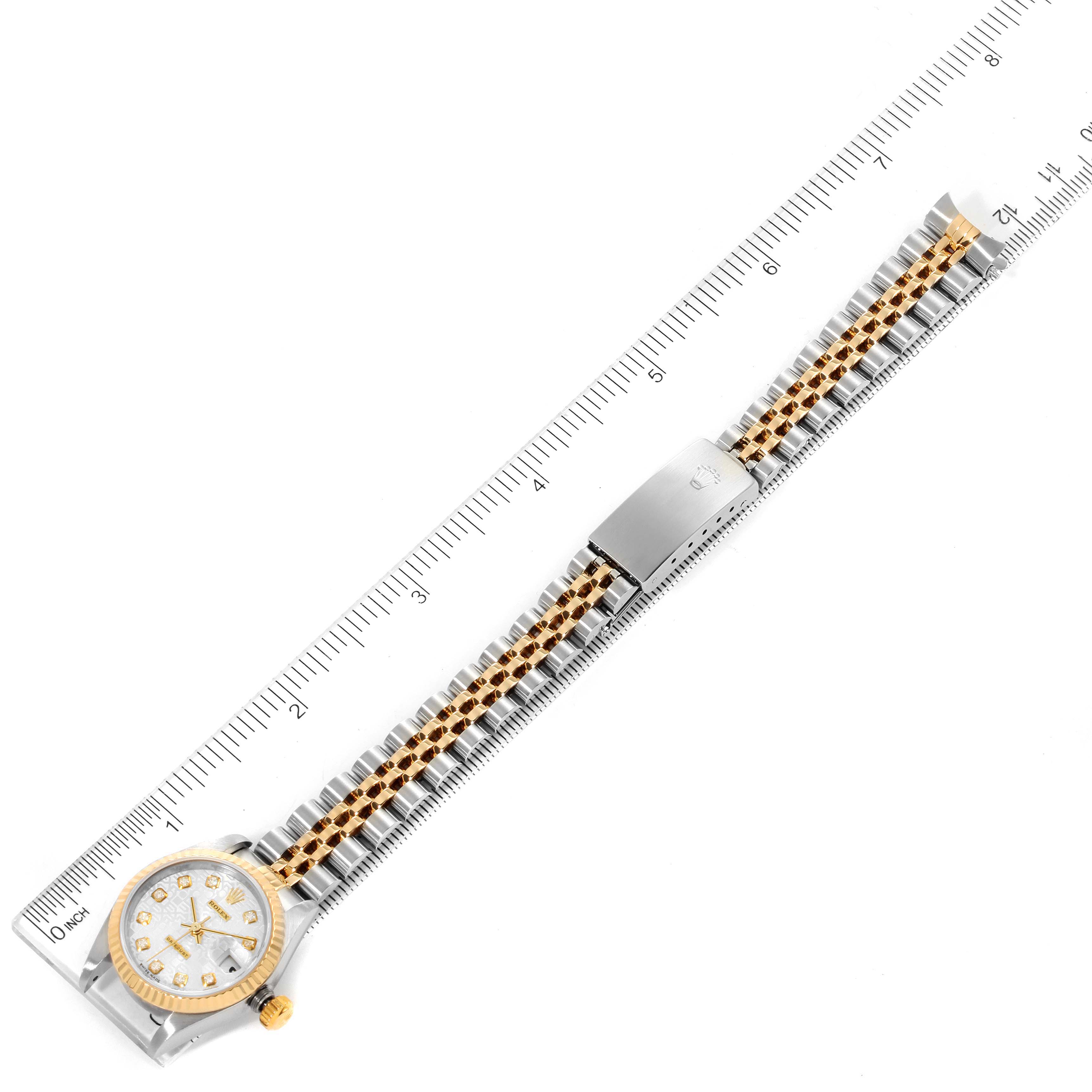 The Rolex Datejust 79173 Women
s Steel and Gold (two tone) Silver Dial 79173 Women
s Steel and Gold (two tone) Silver Dial watch is shown laid flat, with the full length of its band and face visible alongside a measuring ruler.