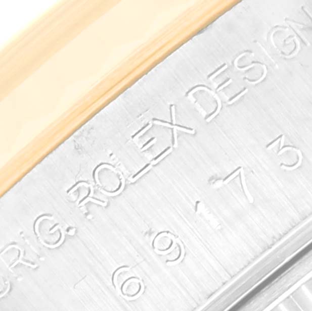 This image shows a close-up of the side engraving on a Rolex Datejust 69173 Women's Steel and Gold (two tone) Mother of Pearl Dial 69173 Women's Steel and Gold (two tone) Mother of Pearl Dial watch case, featuring the model number and "ROLEX DESIGN" text.