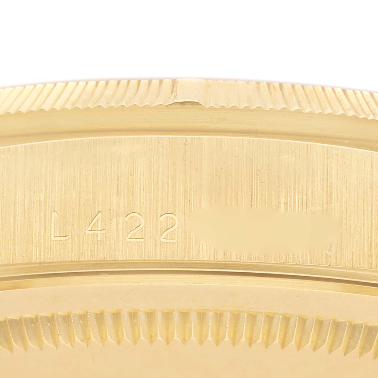 The image shows a close-up of the side view of a Rolex President 18248 Men's Yellow Gold Champagne Dial 18248 Men's Yellow Gold Champagne Dial watch, focusing on the engraved serial number area and fluted bezel.