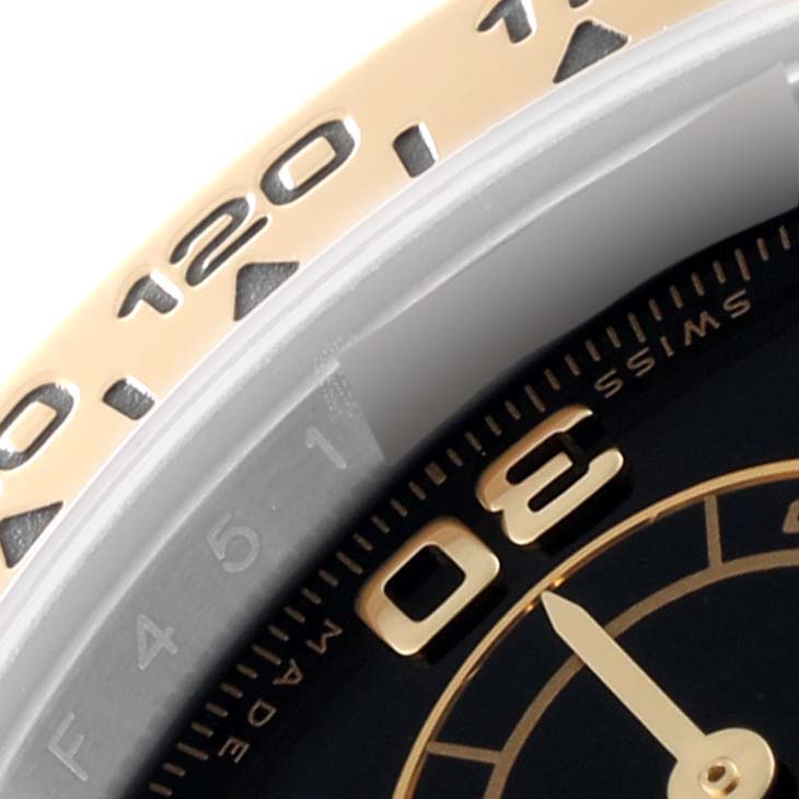 This close-up image of the Rolex Daytona 116503 Men's Steel and Gold (two tone) Black Dial 116503 Men's Steel and Gold (two tone) Black Dial watch shows the bezel, part of the dial, and the numeral markers.