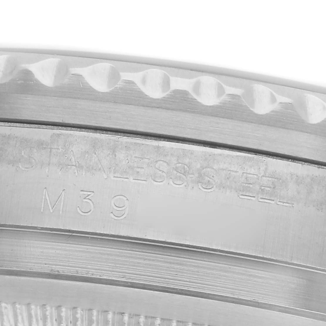 The image shows a close-up of the engraved bezel and edge of a Rolex GMT-Master 116710 Men's Stainless Steel Black Dial 116710 Men's Stainless Steel Black Dial in stainless steel.