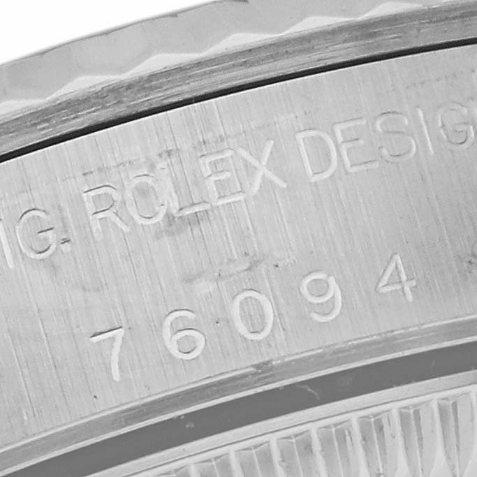 This image shows a close-up of the edge of the case back of a Rolex Oyster Perpetual 76094 Women's Stainless Steel Pink Dial 76094 Women's Stainless Steel Pink Dial watch with engraved details.