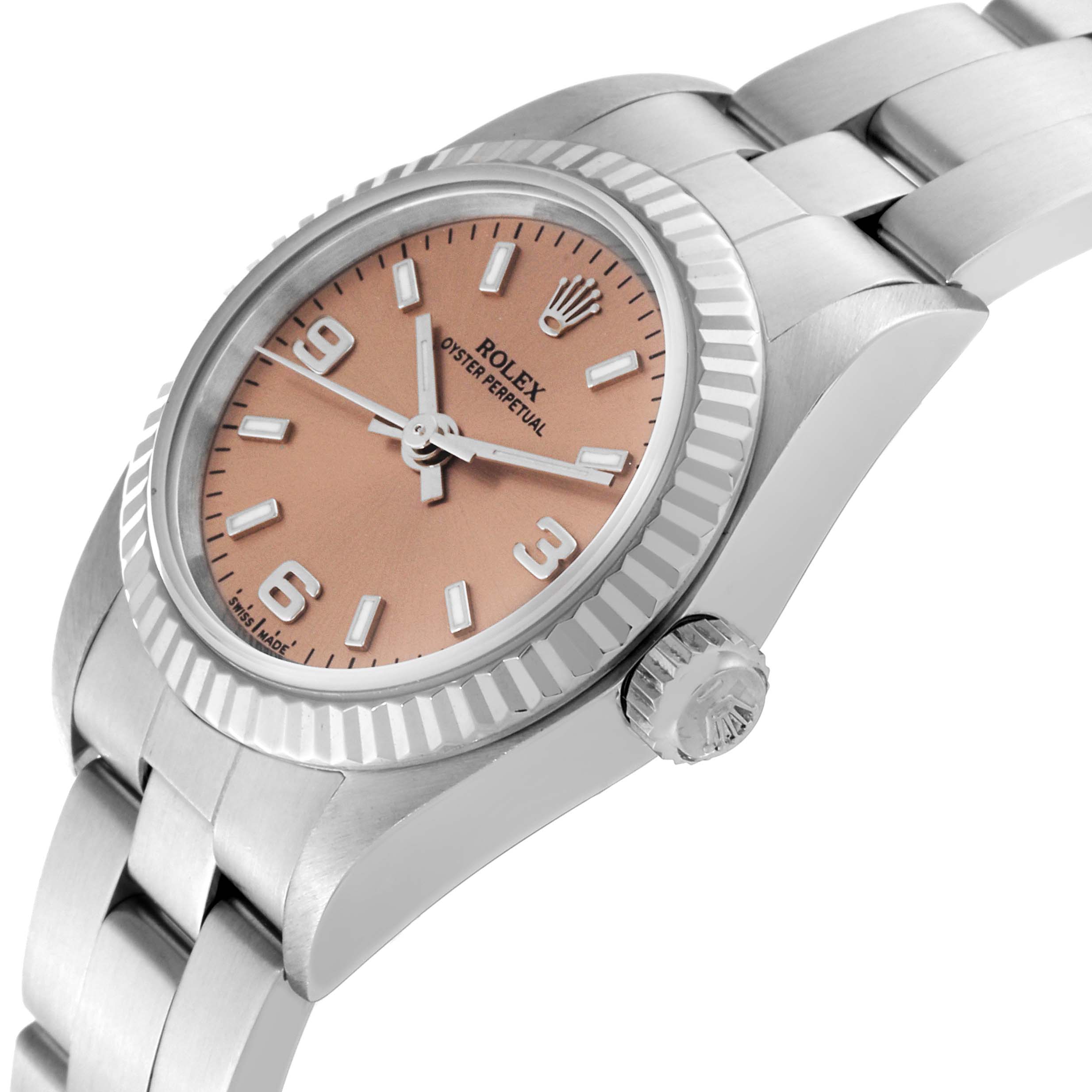 This is a side angle view of a Rolex Oyster Perpetual 76094 Women's Stainless Steel Pink Dial 76094 Women's Stainless Steel Pink Dial watch, showing the face, bezel, crown, and part of the bracelet.