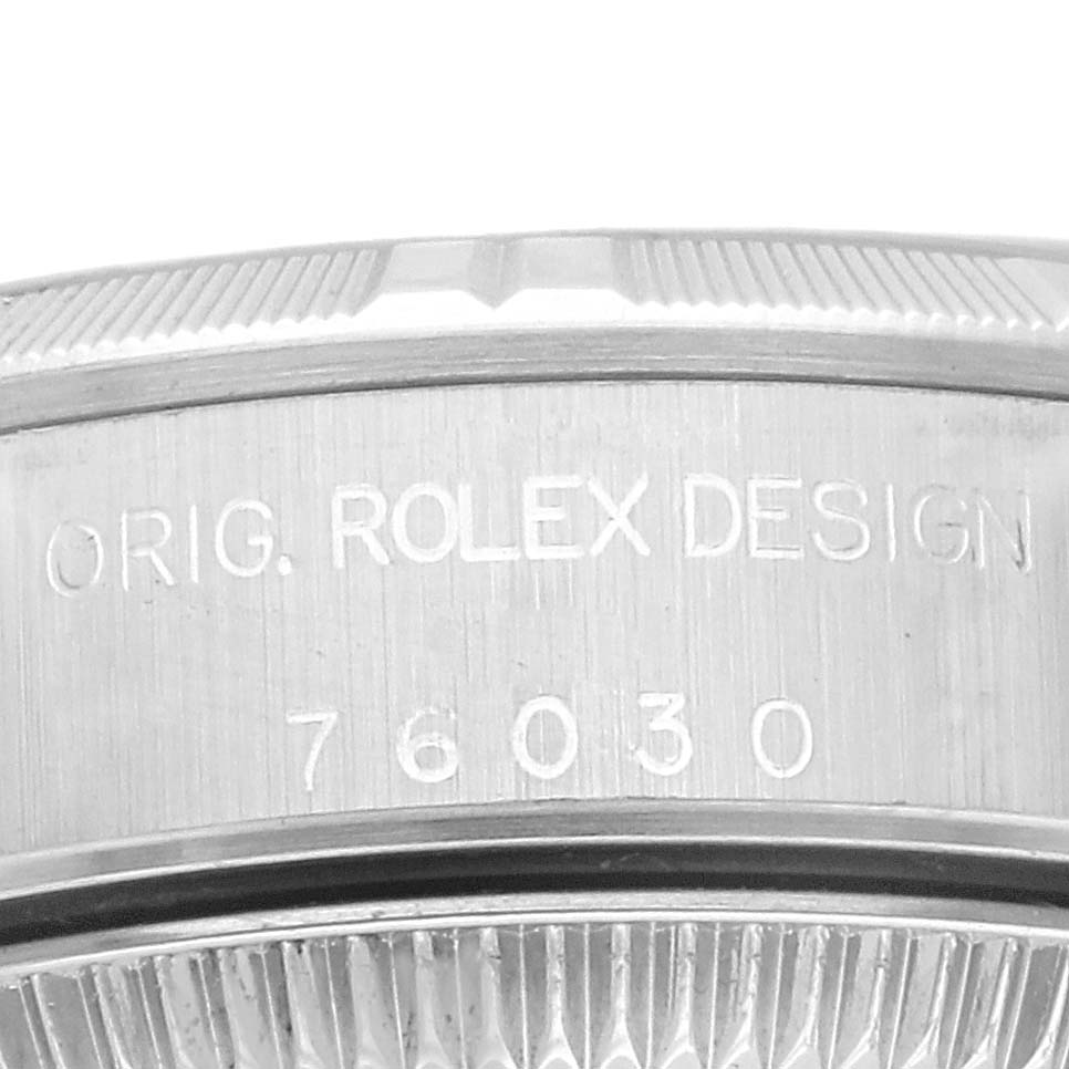 The image shows a close-up of the side engraving on the bezel of a Rolex Oyster Perpetual 76030 Women's Stainless Steel Blue Dial 76030 Women's Stainless Steel Blue Dial watch, displaying "ORIG. ROLEX DESIGN 76030."