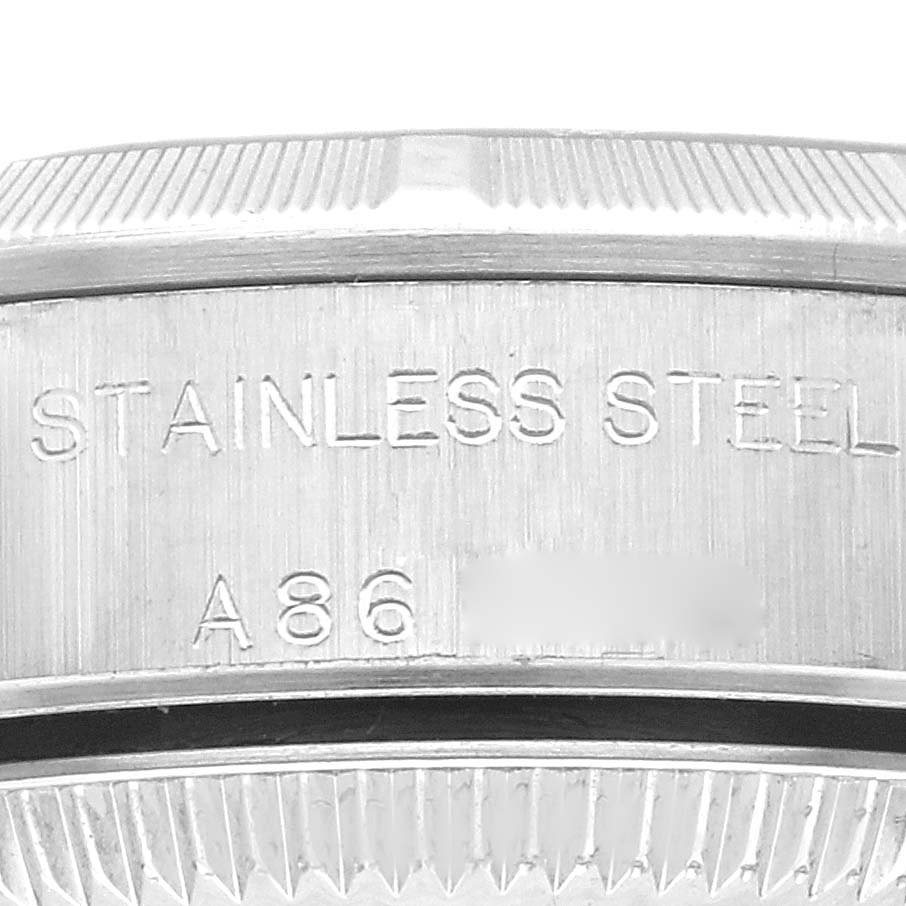 This is a close-up shot of the bezel and part of the case back of a Rolex Oyster Perpetual 76030 Women's Stainless Steel Blue Dial 76030 Women's Stainless Steel Blue Dial watch, showing "STAINLESS STEEL" engraving.