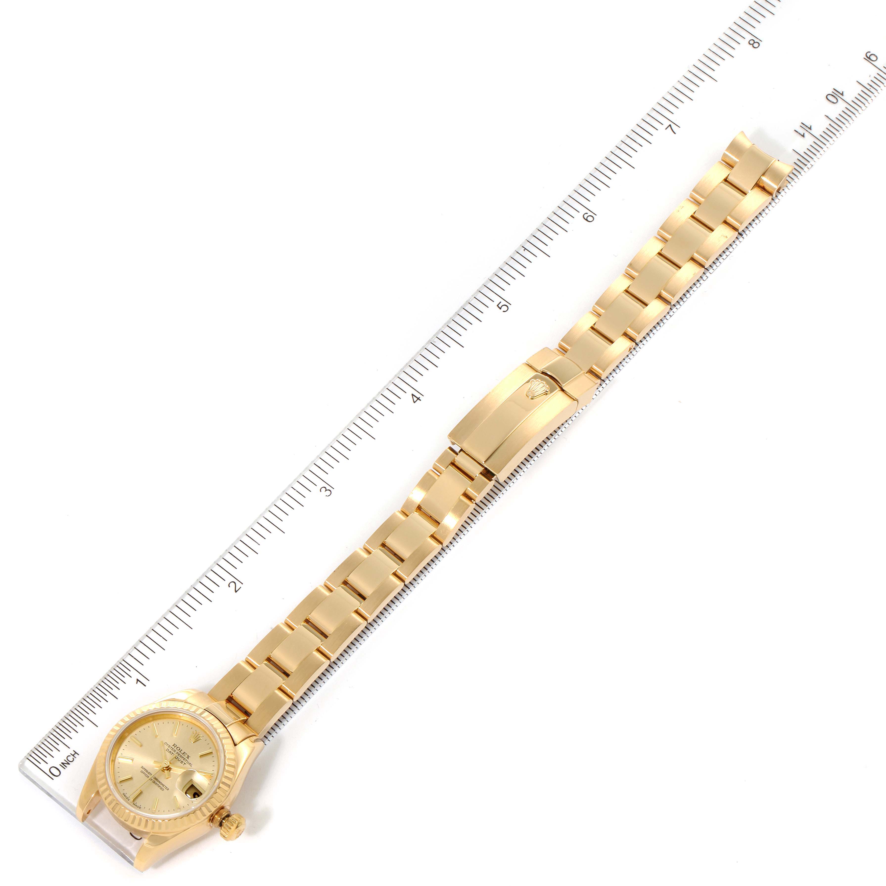 The image shows a full-length view of a Rolex President 179178 Women
s Yellow Gold Champagne Dial 179178 Women
s Yellow Gold Champagne Dial model watch, including the face, band, and clasp, alongside a ruler for scale.