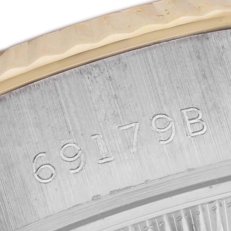 The image shows a close-up of the side with a partial view of the case back of a Rolex President 69179 Women's White Gold Champagne Dial 69179 Women's White Gold Champagne Dial model watch, displaying the engraved serial number.