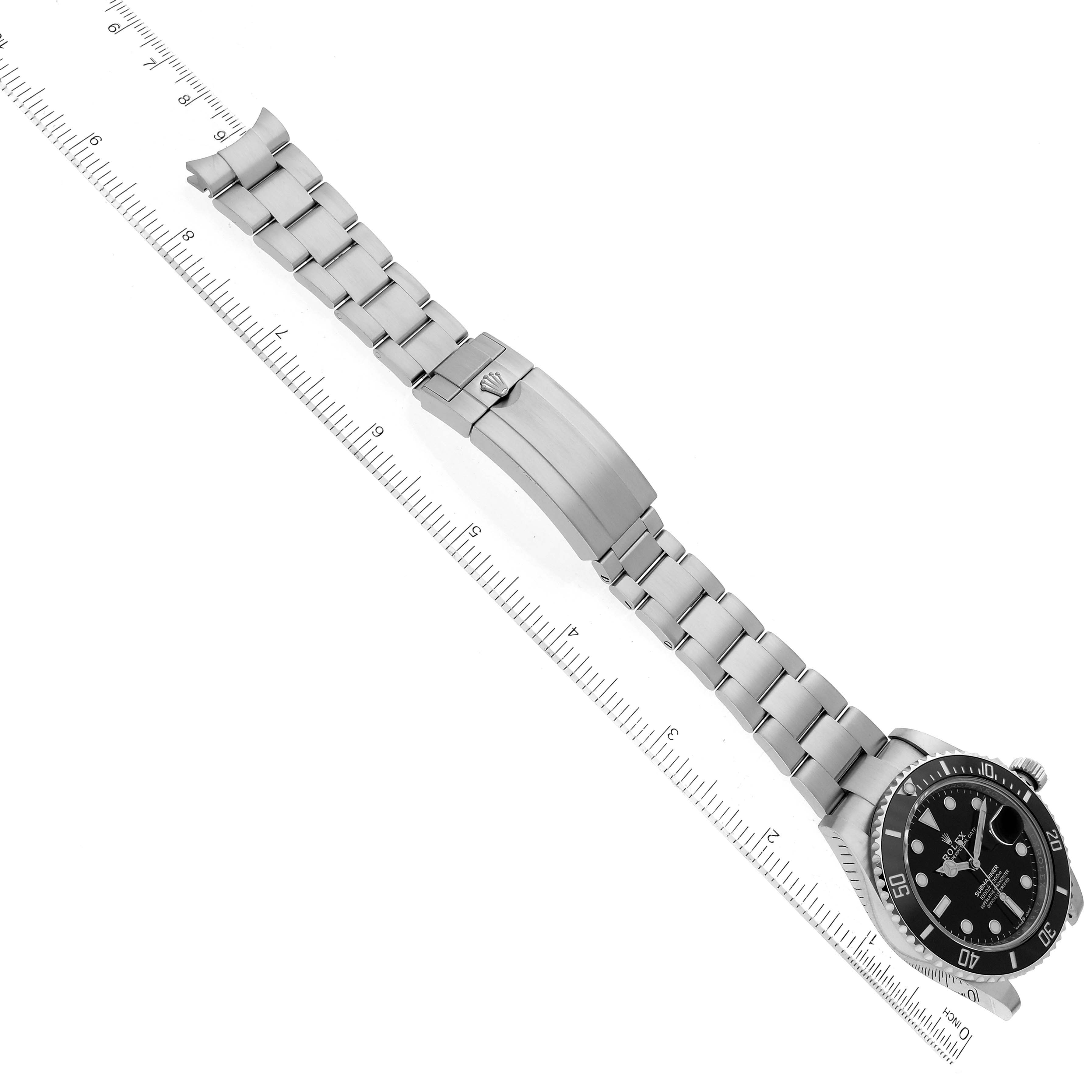 This image shows the full length of a Rolex Submariner 126610 Men
s Stainless Steel Black Dial 126610 Men
s Stainless Steel Black Dial watch laid flat, including the watch
s face, bezel, and bracelet, positioned next to a ruler.