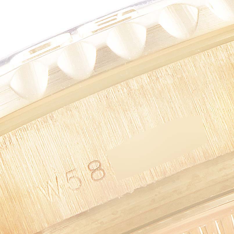 Close-up of the side of a Rolex Yacht-Master 69628 Women's Yellow Gold Blue Dial 69628 Women's Yellow Gold Blue Dial watch, showing part of the bezel and a section of engraved text on the case.