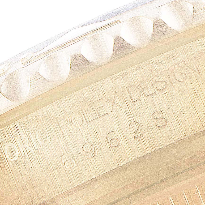 The image shows a close-up of the bezel and engraved serial number of a Rolex Yacht-Master 69628 Women's Yellow Gold Blue Dial 69628 Women's Yellow Gold Blue Dial watch.