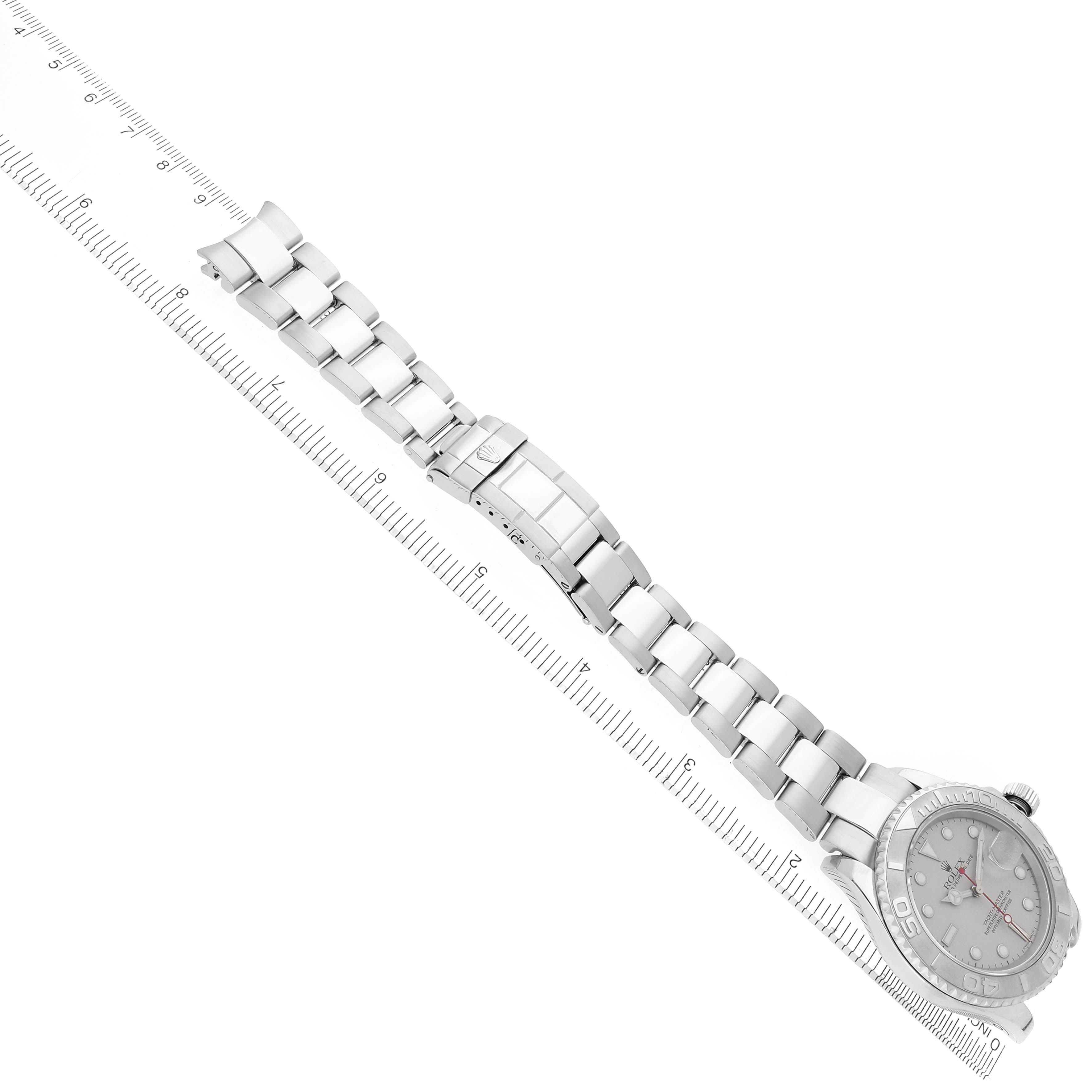 The image shows a top-down view of a Rolex Yacht-Master 16622 Men's Stainless Steel Silver Dial 16622 Men's Stainless Steel Silver Dial watch with its band aligned with a ruler.