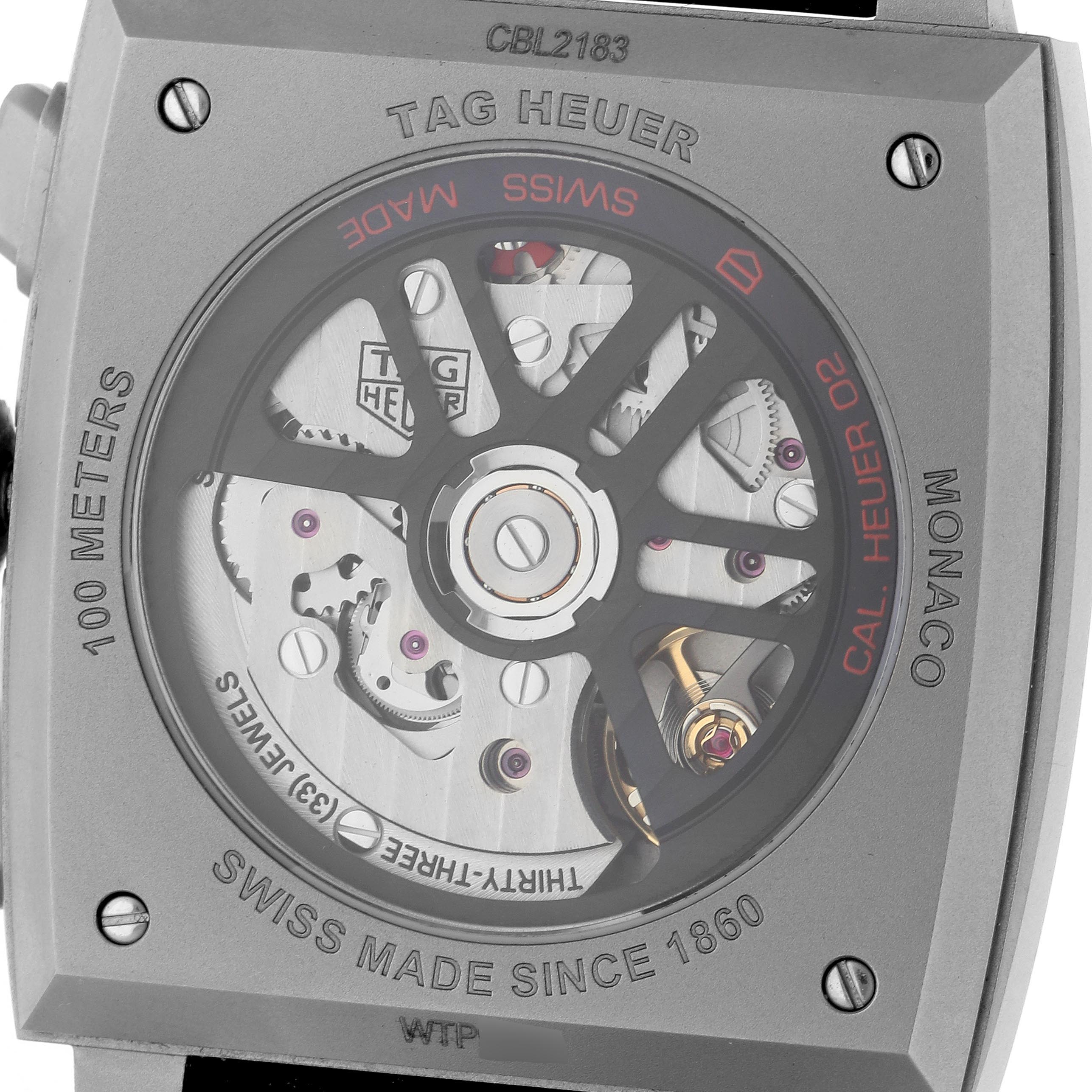 The image shows the back of the Tag Heuer Monaco CBL2183.FT6236 Men's Titanium Black Dial CBL2183.FT6236 Men's Titanium Black Dial watch, highlighting its exposed movement and inscriptions.
