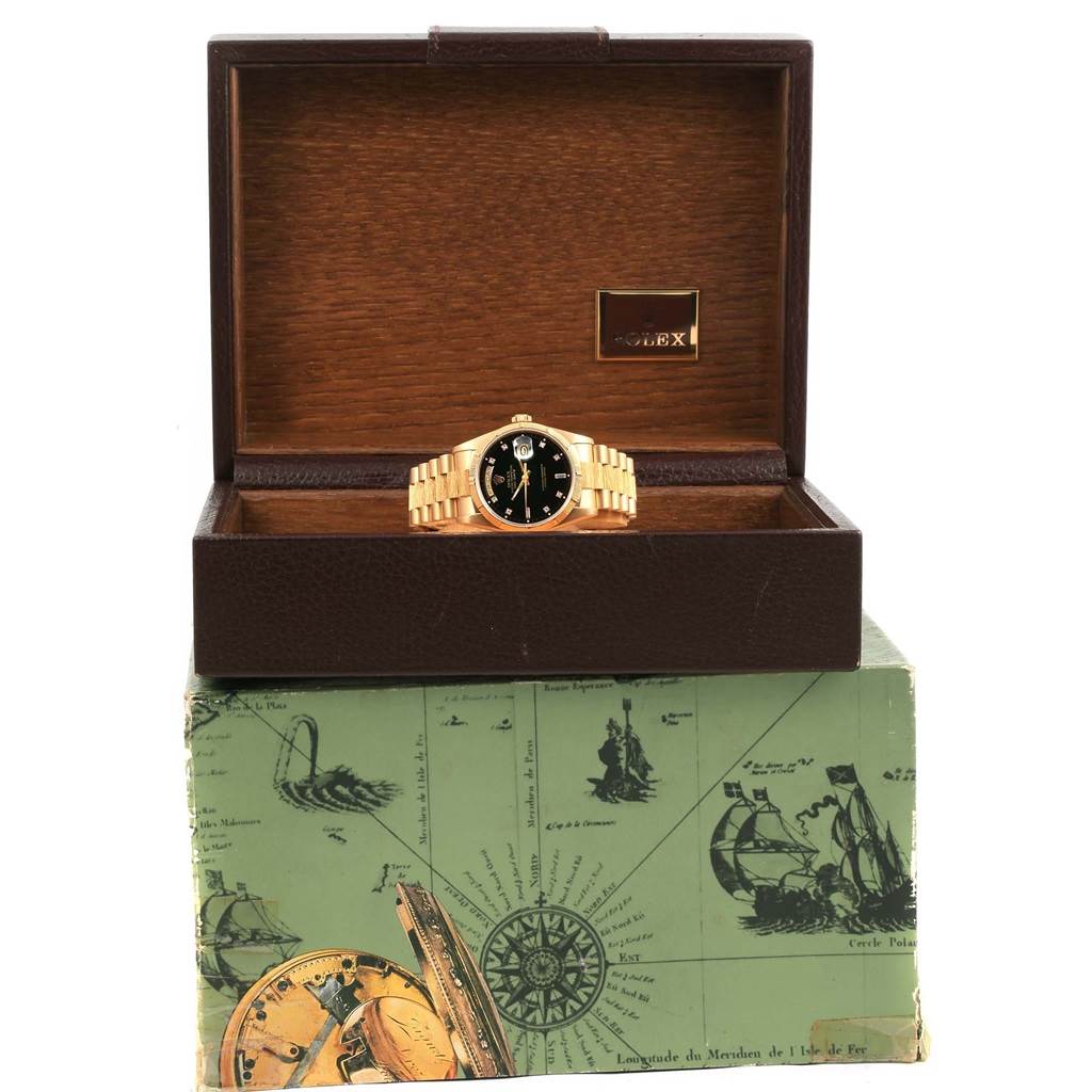 The Rolex 18248 Men's Yellow Gold Black Dial 18248 Men's Yellow Gold Black Dial Day-Date President Yellow Gold Black Diamond Dial Mens Watch 18248 is displayed front-facing inside its open box on a decorative base.