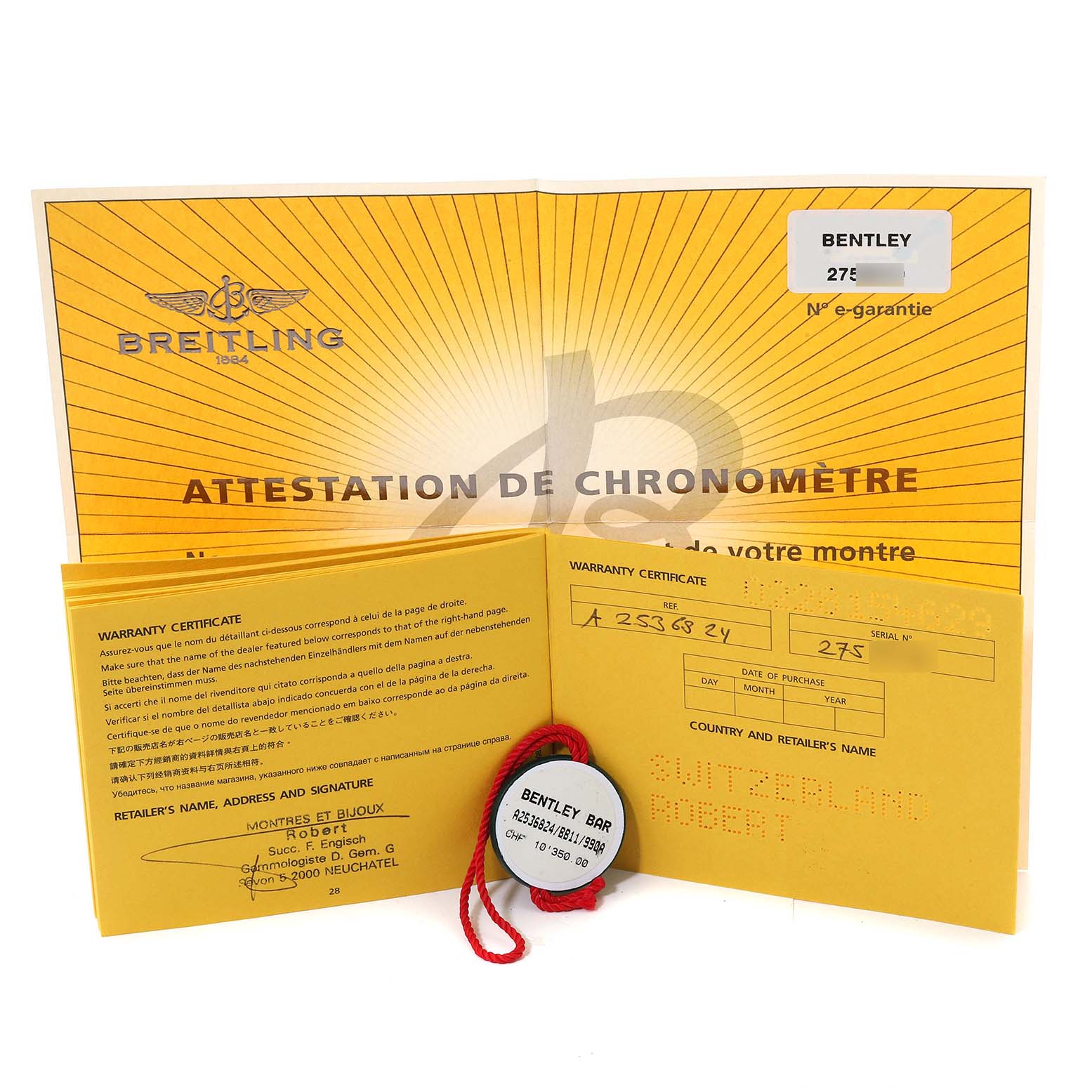The image shows the warranty certificates and tag for a Bentley model by Breitling, displayed at a slight angle.