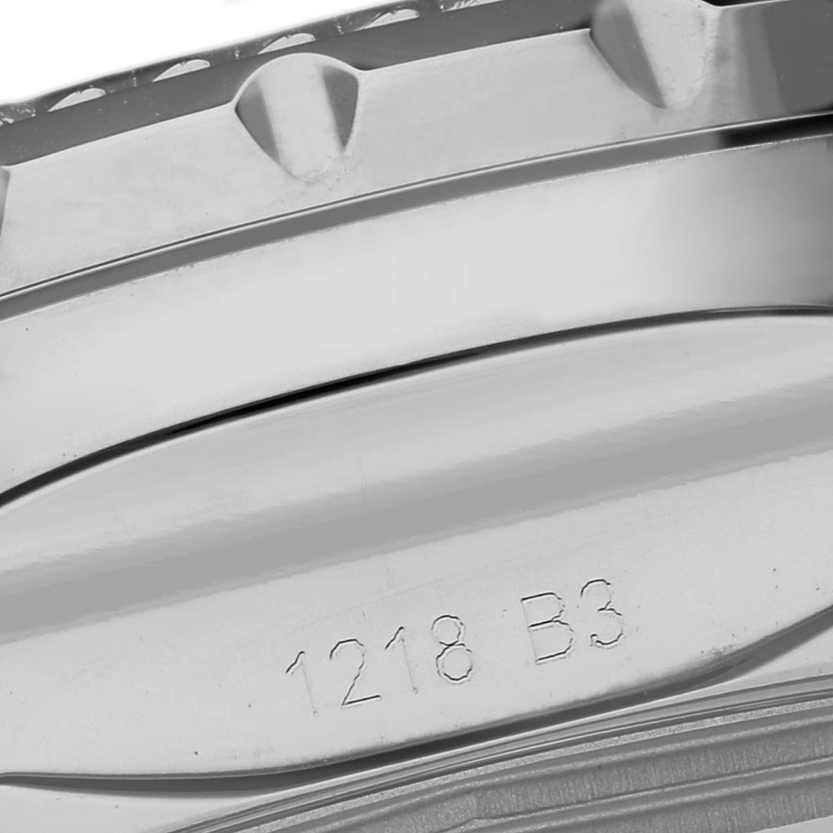 The image shows a close-up of the bezel and part of the case back of a Bentley model watch by Breitling, etched with "1218 B3."