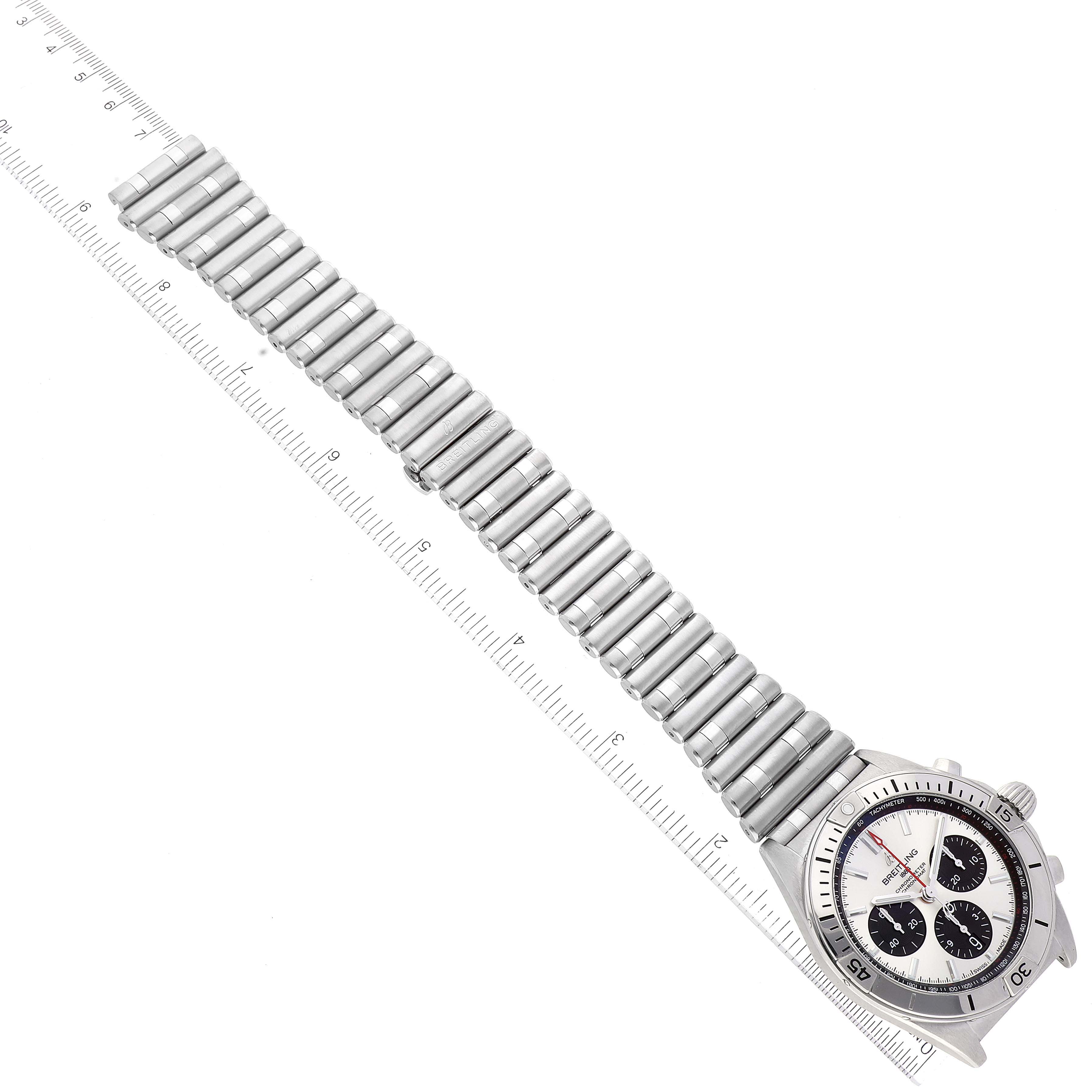The Breitling Chronomat AB0134 Men
s Stainless Steel Silver Dial AB0134 Men
s Stainless Steel Silver Dial watch is shown from an overhead angle, displaying its full bracelet and bezel with a measuring ruler next to it.