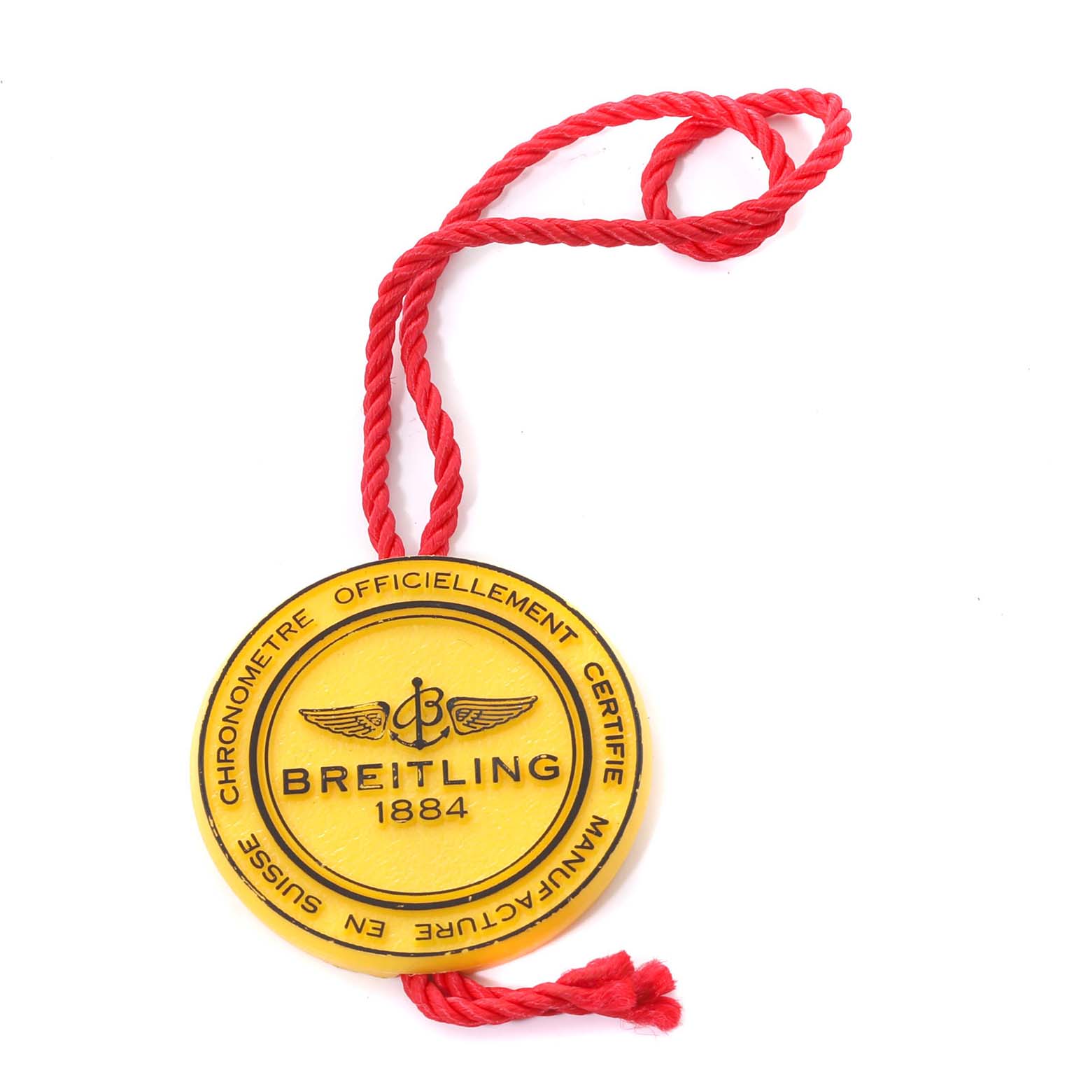 This image shows a Breitling Navitimer K35330 Men's Yellow Gold Silver Dial K35330 Men's Yellow Gold Silver Dial certification tag with a yellow medallion and red string.