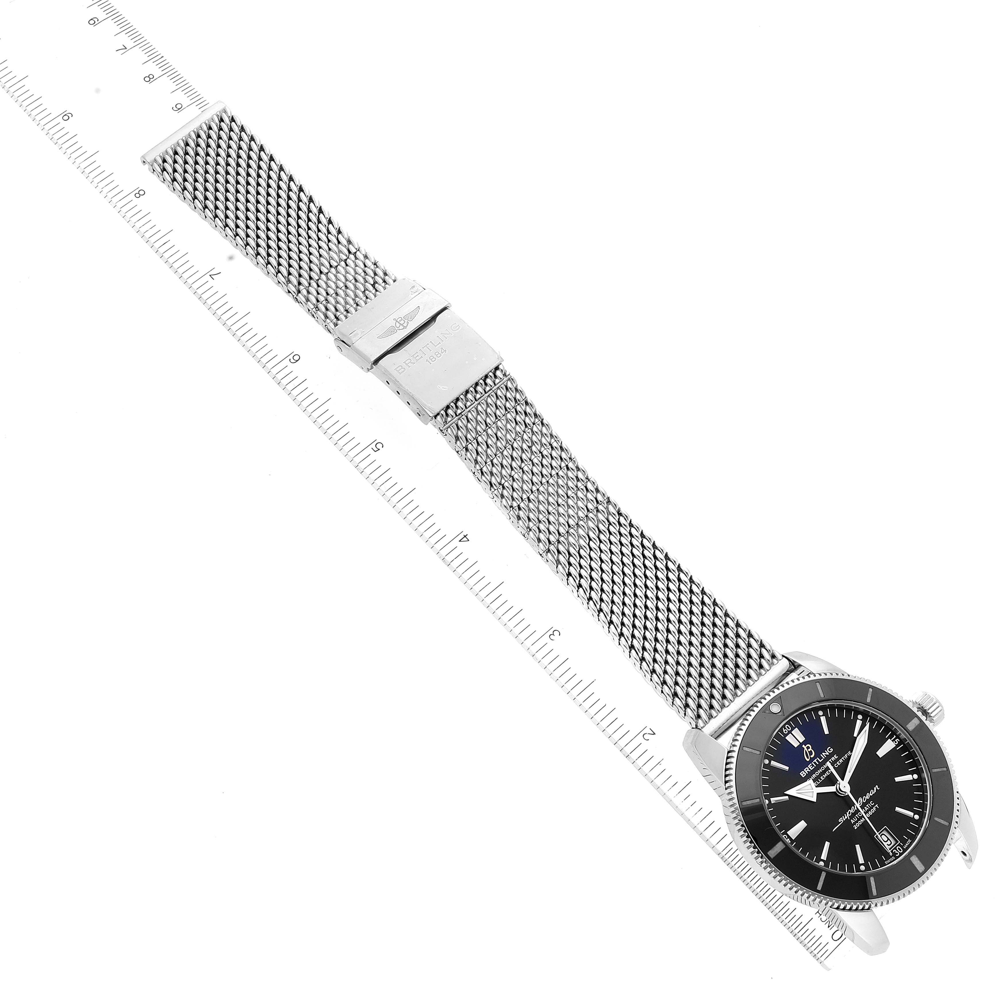 The image shows a Breitling Superocean AB2010161C1A1 Men's Stainless Steel Black Dial AB2010161C1A1 Men's Stainless Steel Black Dial watch and its entire length, lying flat with mesh strap extended, next to a ruler.