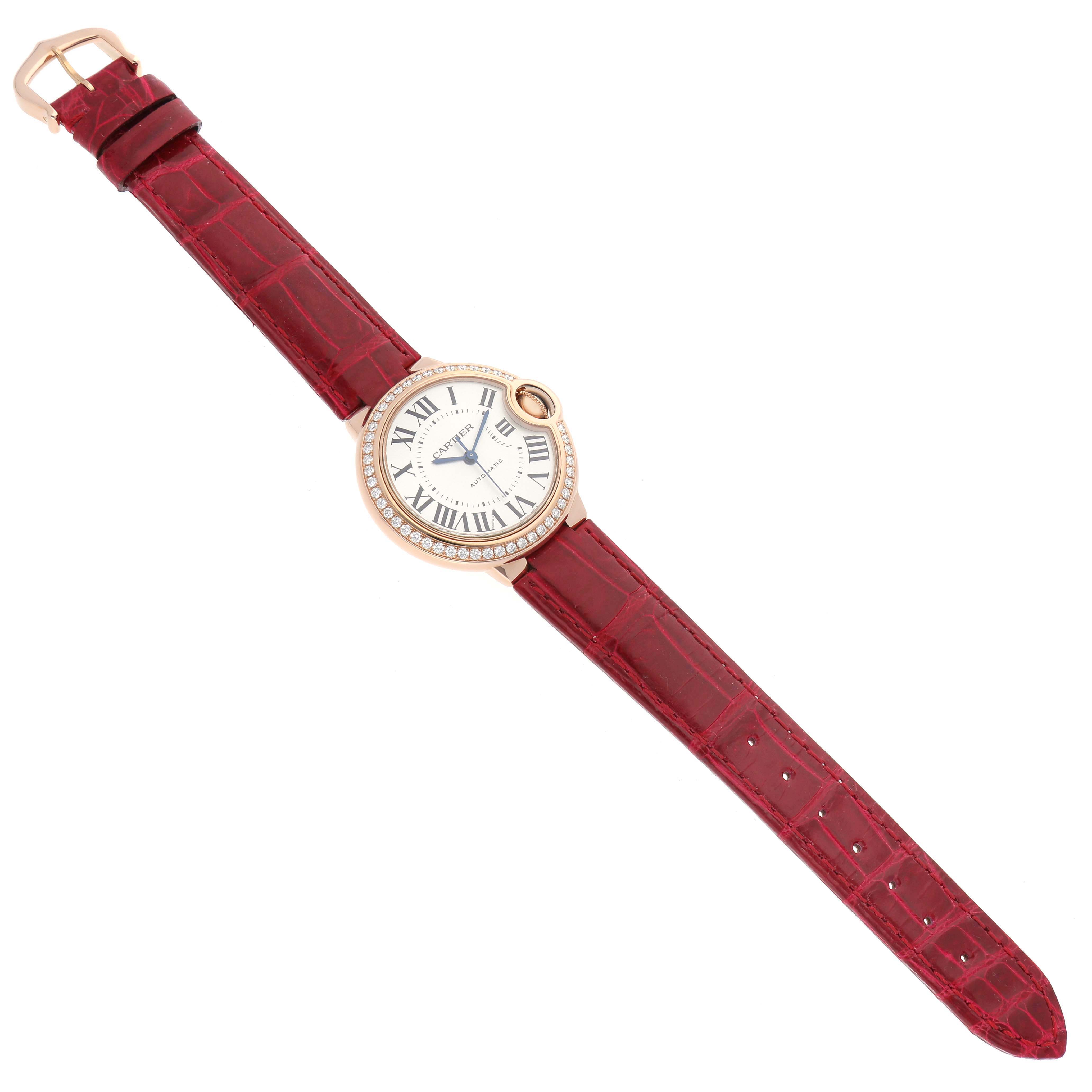 The Cartier Ballon Bleu WJBB0033 Women's Rose Gold Silver Dial watch is shown from a top-down angle, displaying its dial, case, and red leather strap.