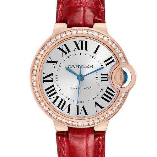 The Cartier Ballon Bleu WJBB0033 Women's Rose Gold Silver Dial watch is shown from the front, highlighting the dial, Roman numerals, and crown with a red strap.