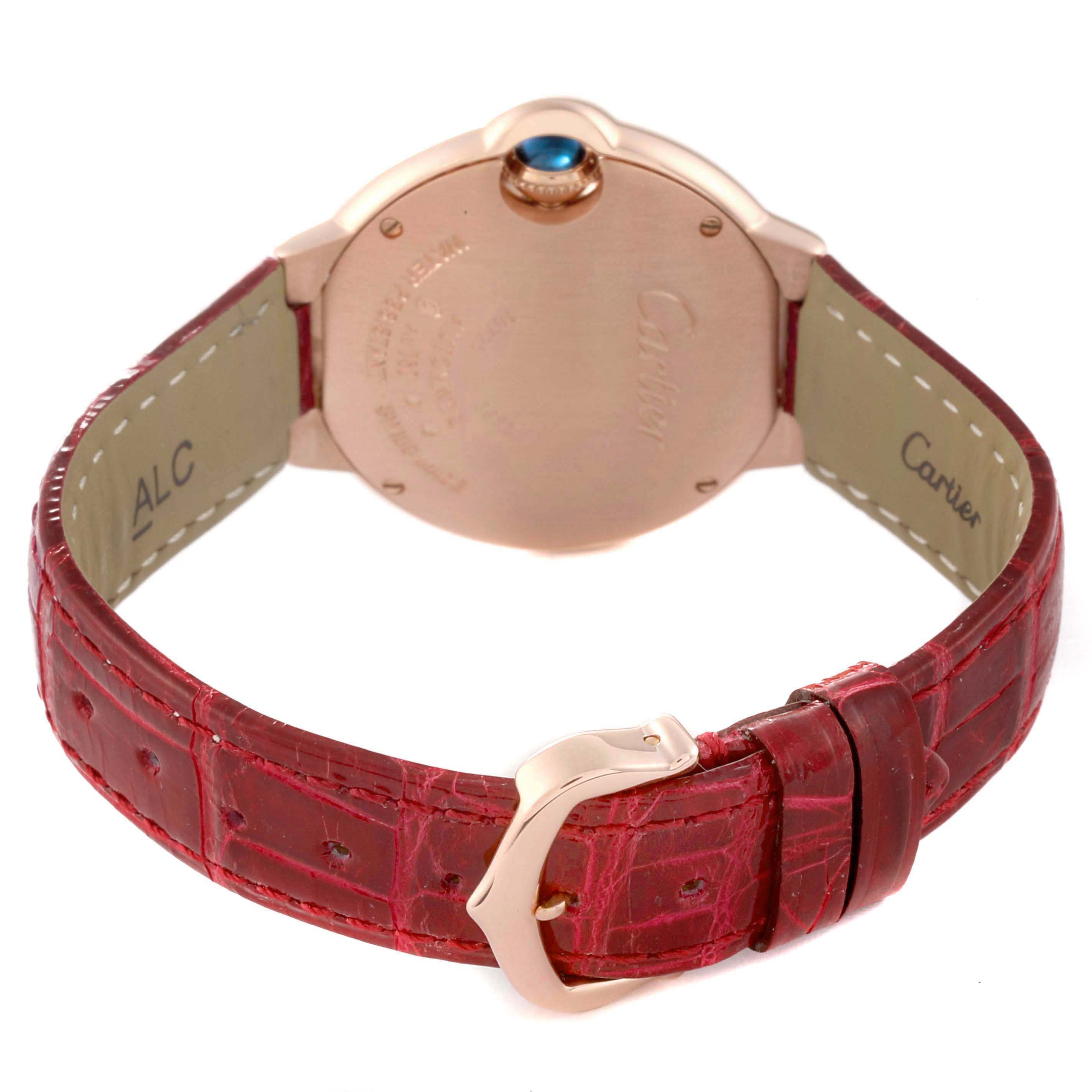 The Cartier Ballon Bleu WJBB0033 Women's Rose Gold Silver Dial watch is shown from the back, displaying the case back, crown, and red leather strap with buckle.