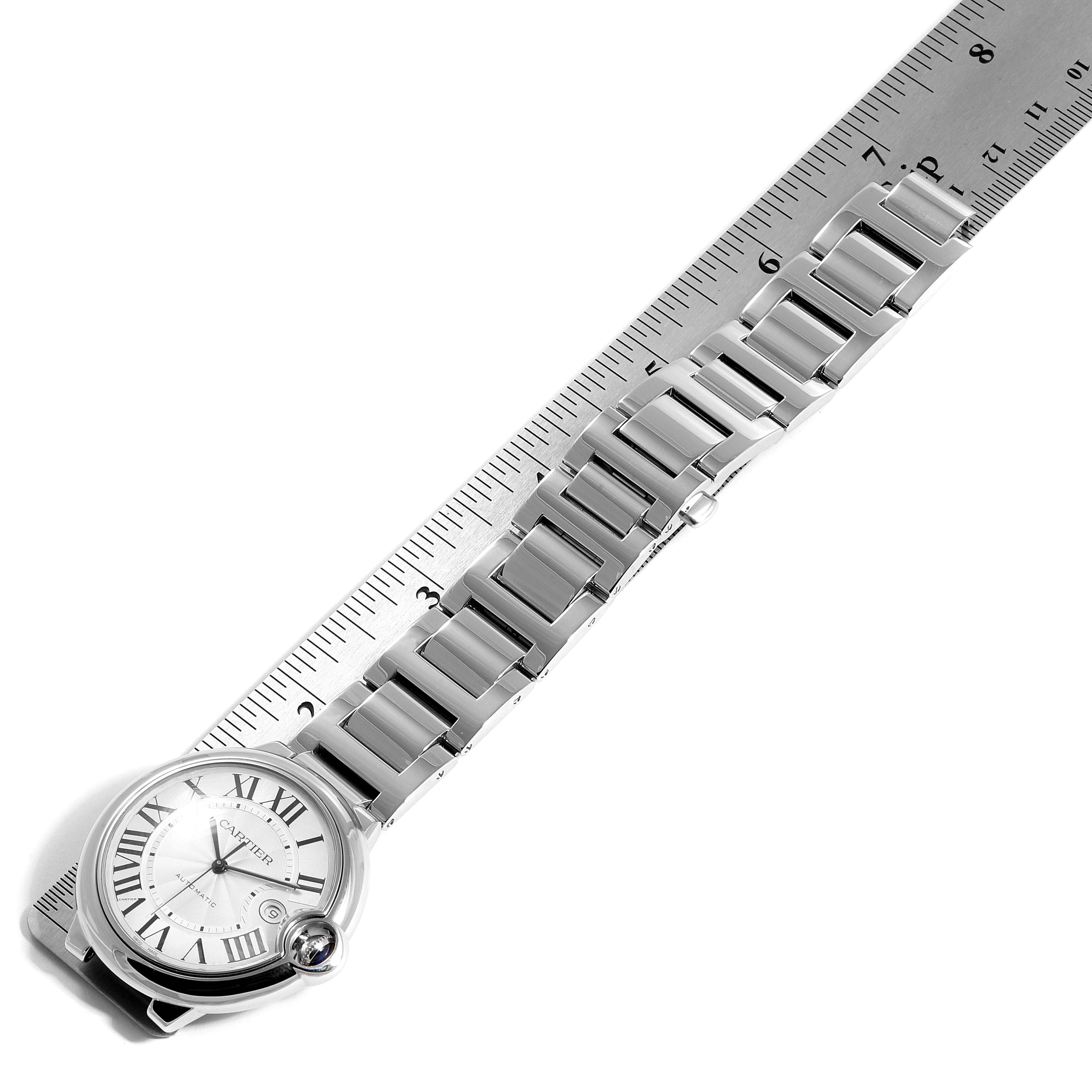 The Cartier Ballon Bleu W69012Z4 Men's Stainless Steel Silver Dial W69012Z4 Men's Stainless Steel Silver Dial watch is shown from a top-down angle, displaying its face and metal bracelet alongside a ruler.