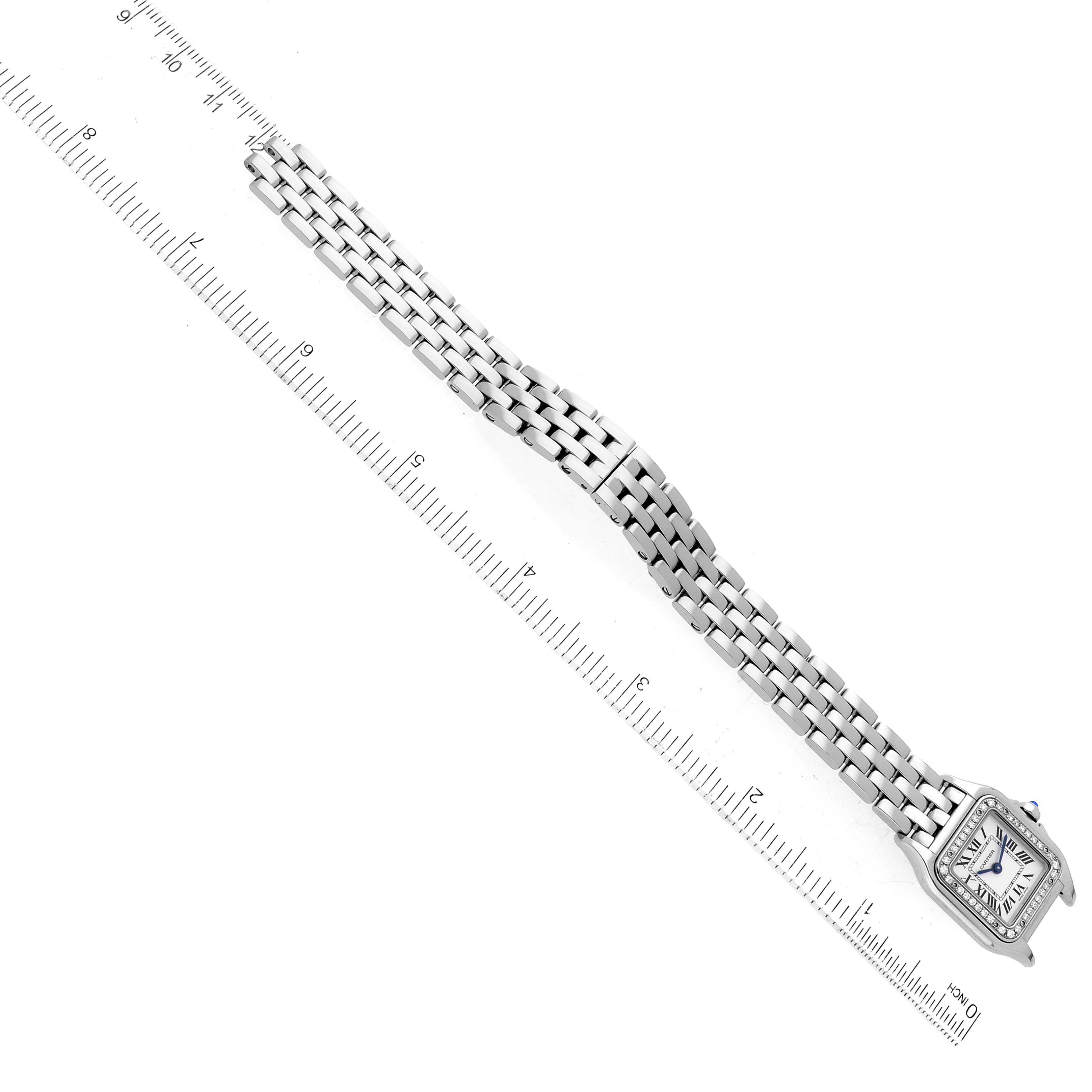 The image shows an overhead view of a Cartier Panthere W4PN0007 Women's Stainless Steel Silver Dial W4PN0007 Women's Stainless Steel Silver Dial watch, displaying its face and metal band alongside a ruler for scale.