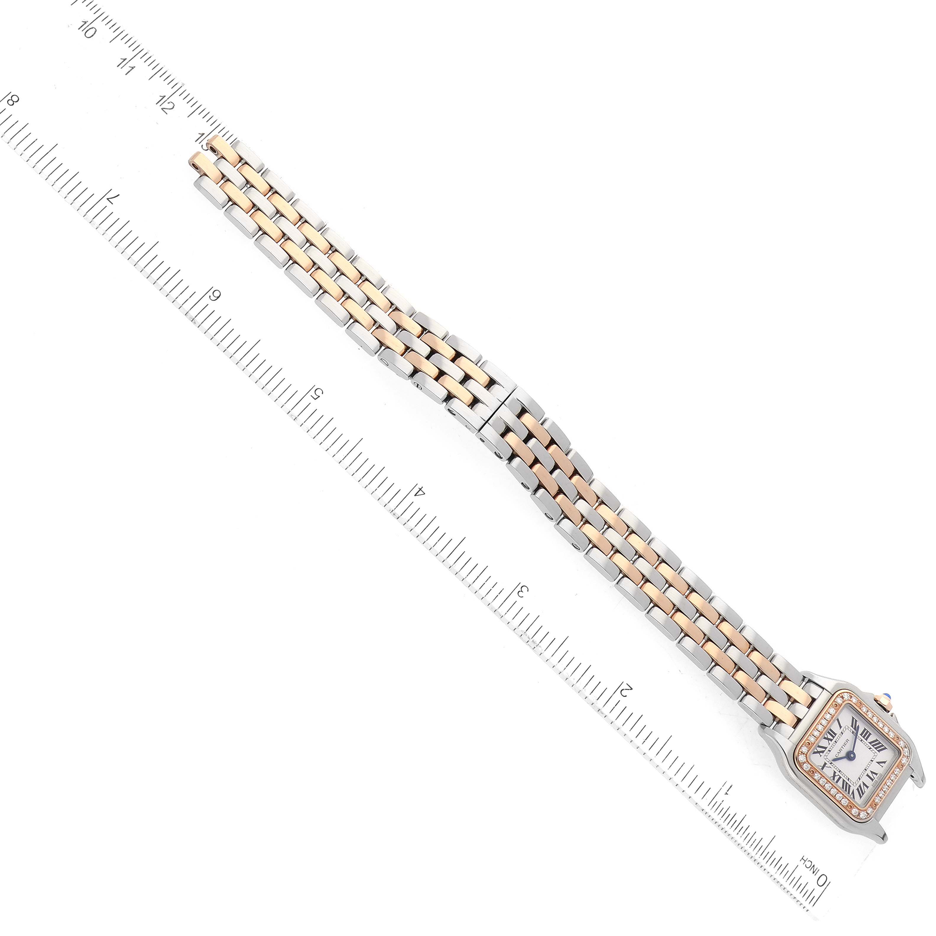 The image shows a Panthere model by Cartier watch from a top-down angle with its bracelet stretched out alongside a ruler.
