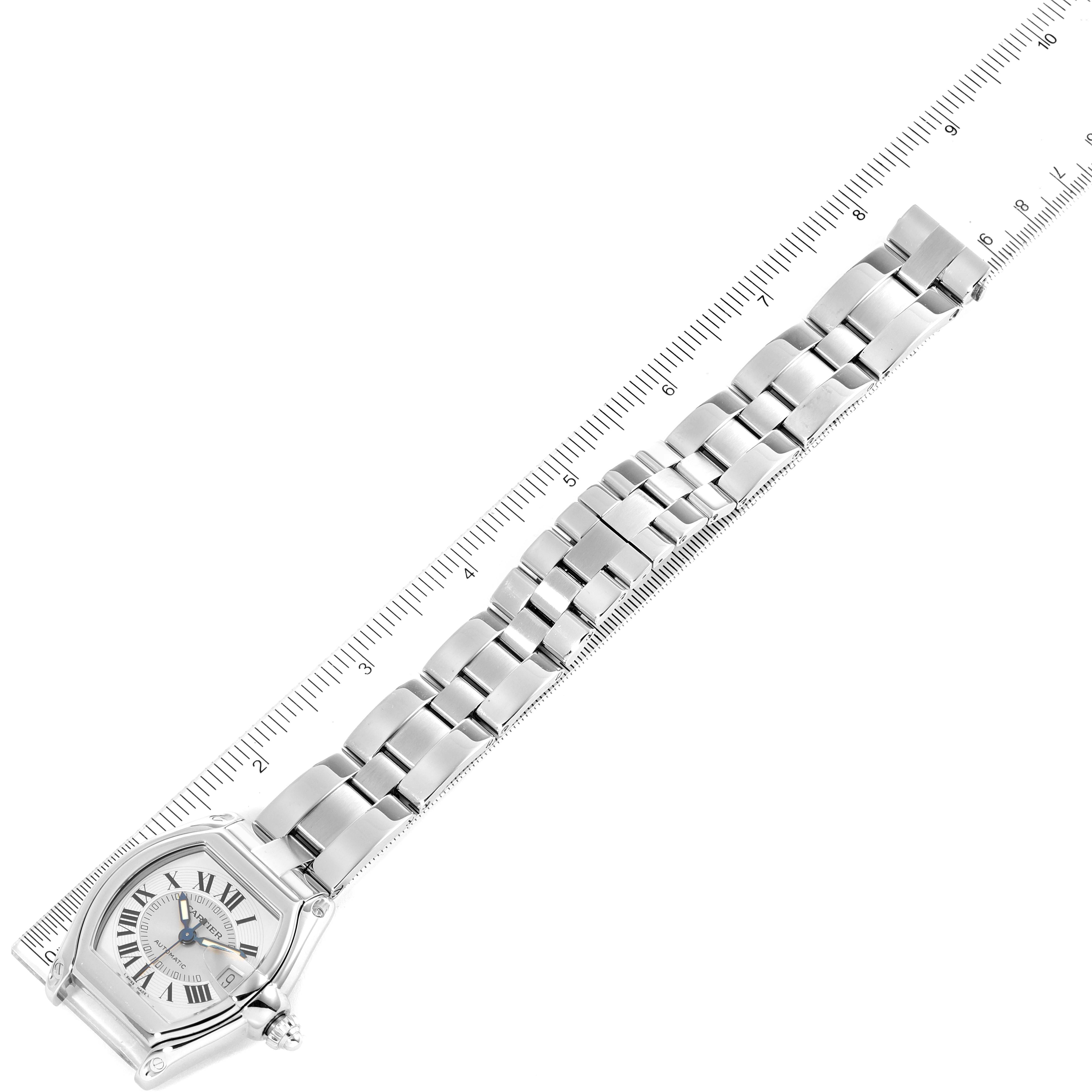 This image shows a Roadster model by Cartier viewed from a top angle, displaying the face and metal bracelet against a ruler.