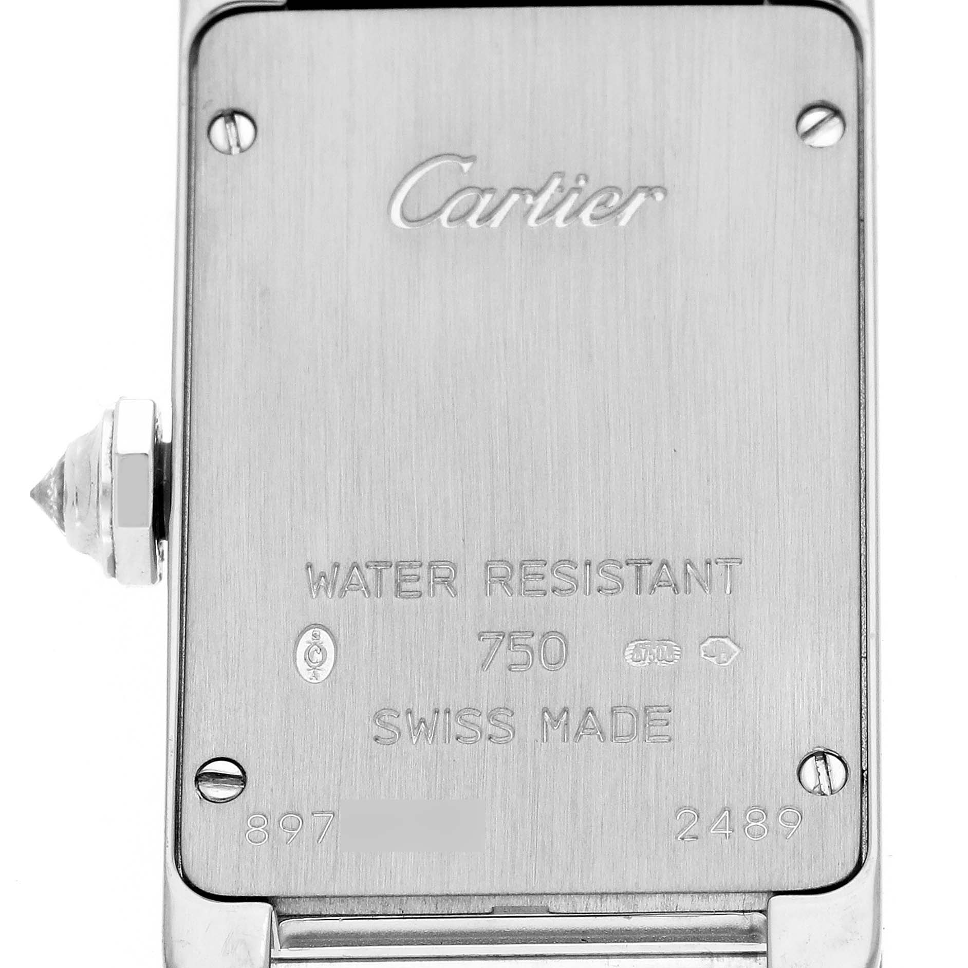 This image shows the back case of a Tank Americaine model by Cartier, featuring engraved details and a visible crown on the left.