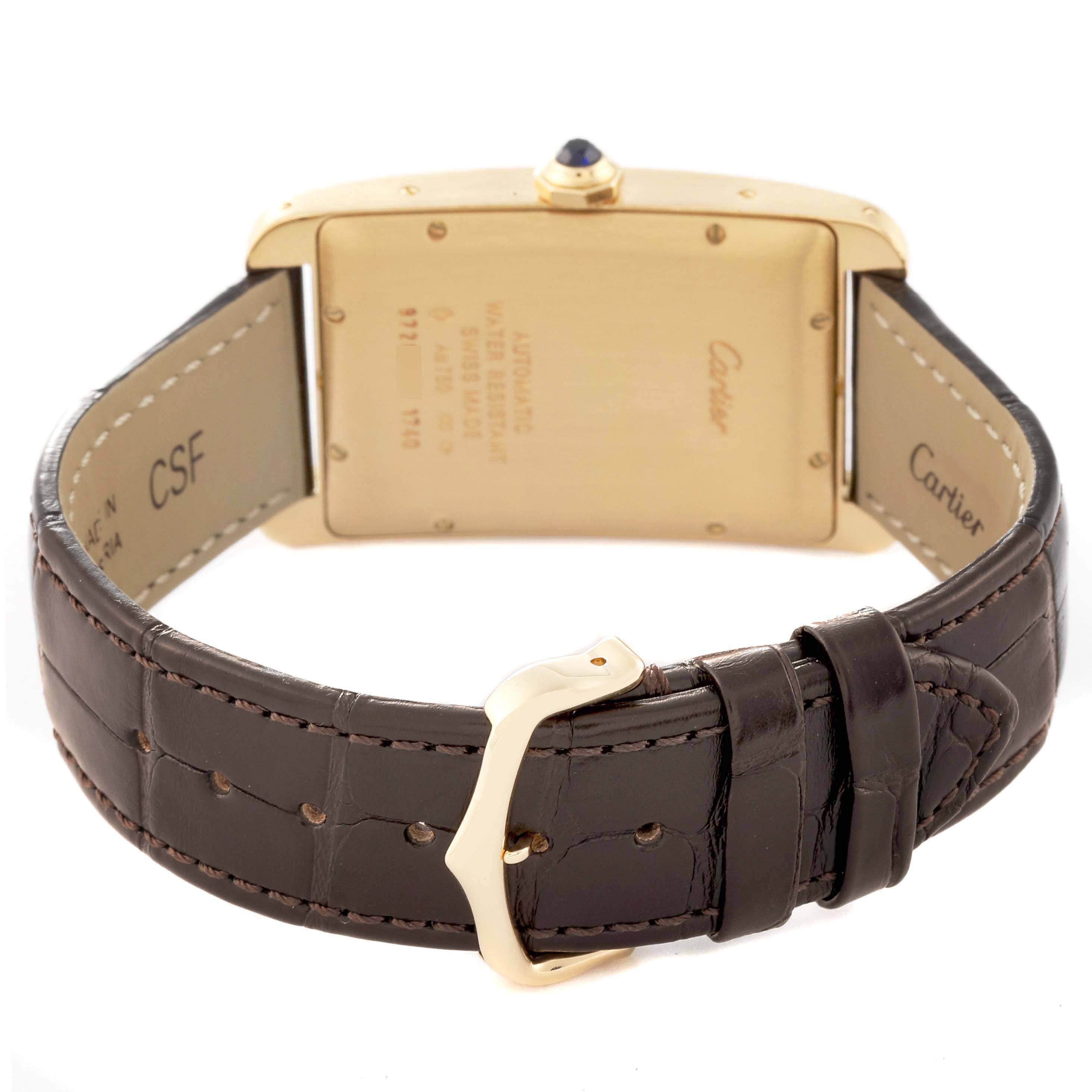 The image shows the back view of a Cartier Tank Americaine W2603156 Men's Yellow Gold Silver Dial W2603156 Men's Yellow Gold Silver Dial watch, highlighting its clasp, leather strap, and case back.