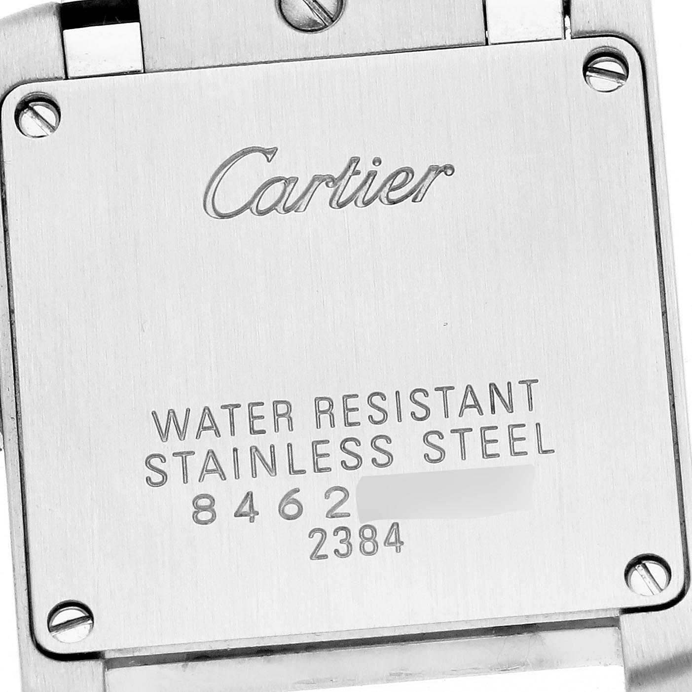The image shows the back case of a Cartier Tank Française watch with engraving details and screws visible.