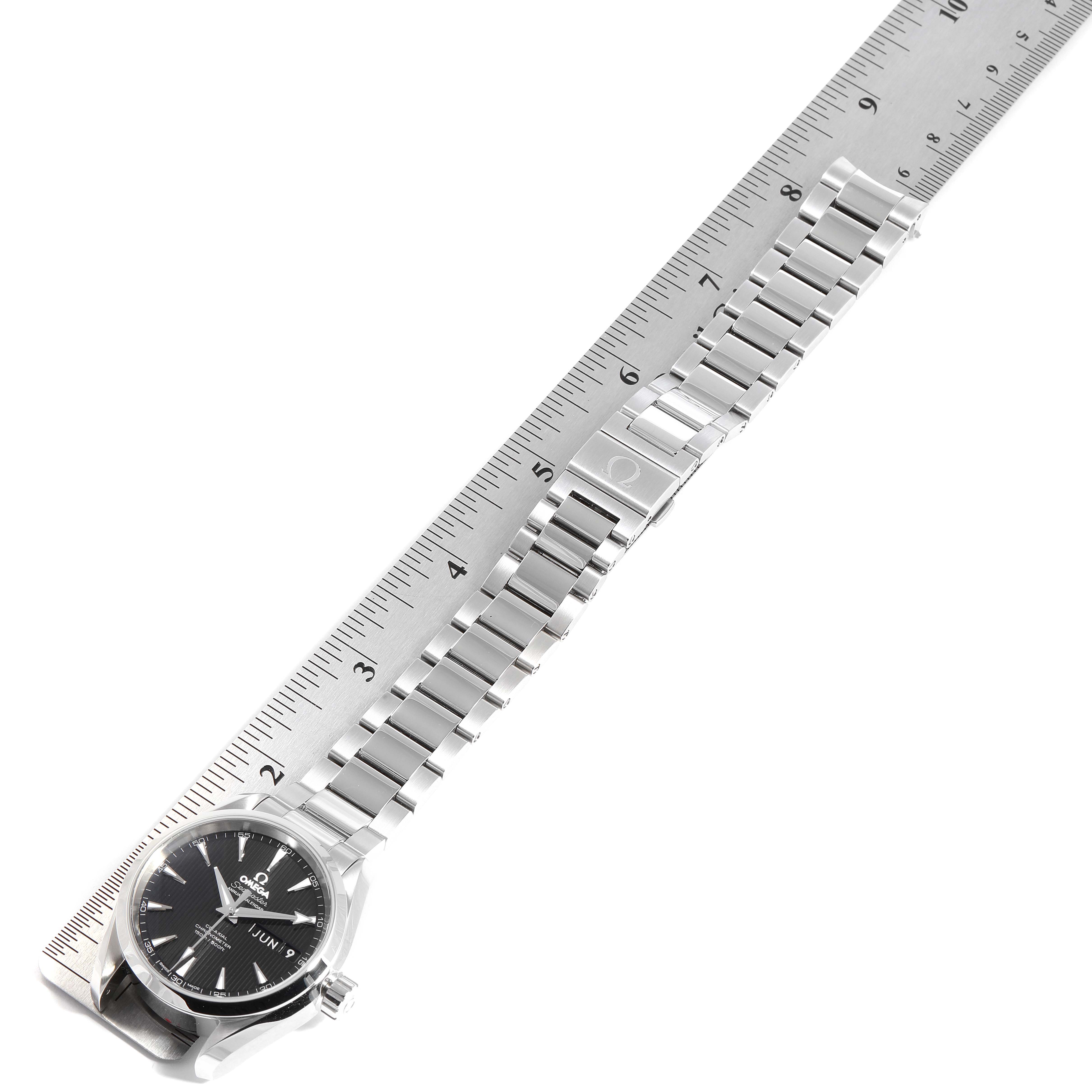 The image shows an Omega Aqua Terra 231.10.39.22.01.001 Men's Stainless Steel Black Dial 231.10.39.22.01.001 Men's Stainless Steel Black Dial watch placed along a ruler, highlighting the face and metal bracelet.