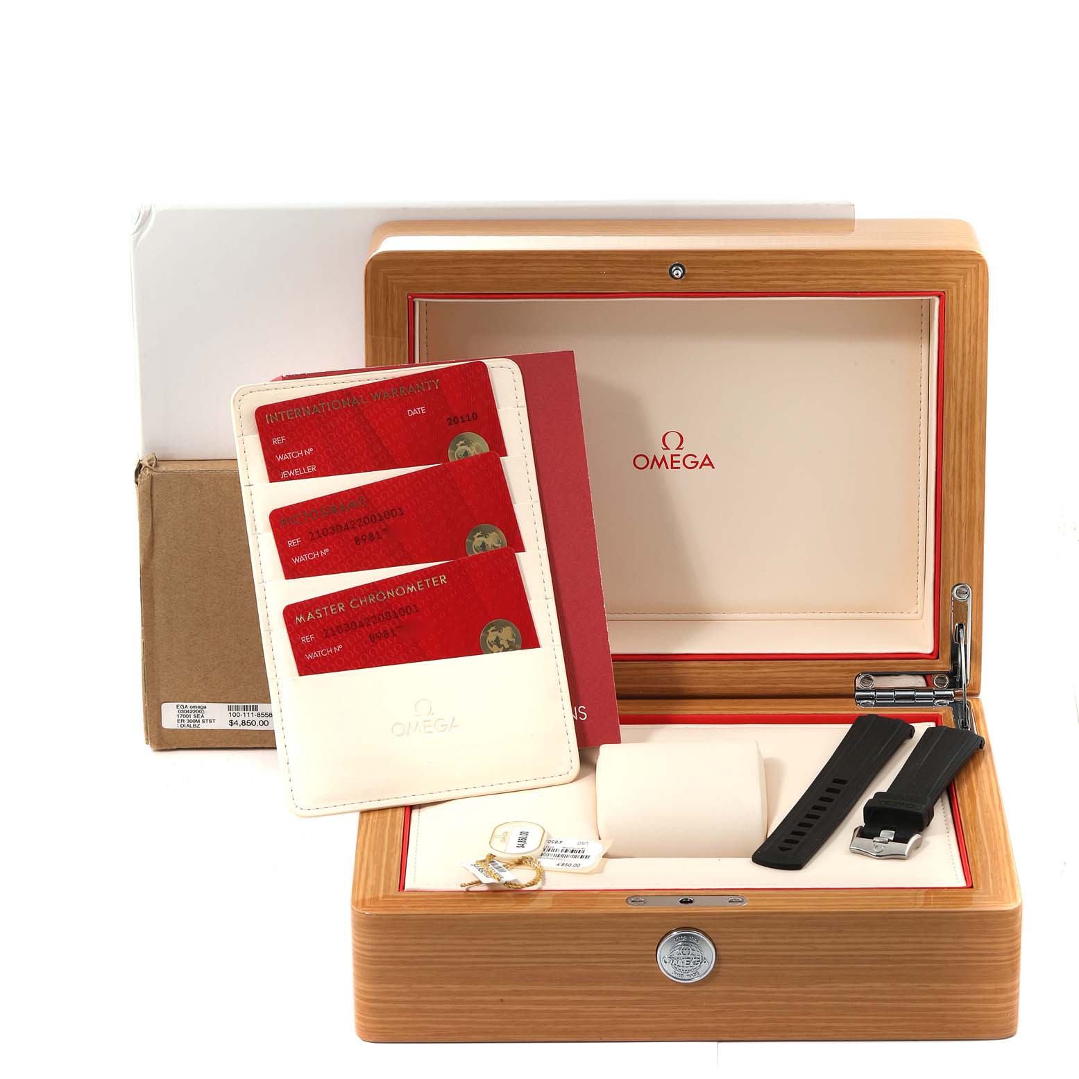 The image shows the open box of an Omega Seamaster 210.30.42.20.01.001 Men
s Stainless Steel Black Dial 210.30.42.20.01.001 Men
s Stainless Steel Black Dial watch including the warranty cards, extra strap, and tags.