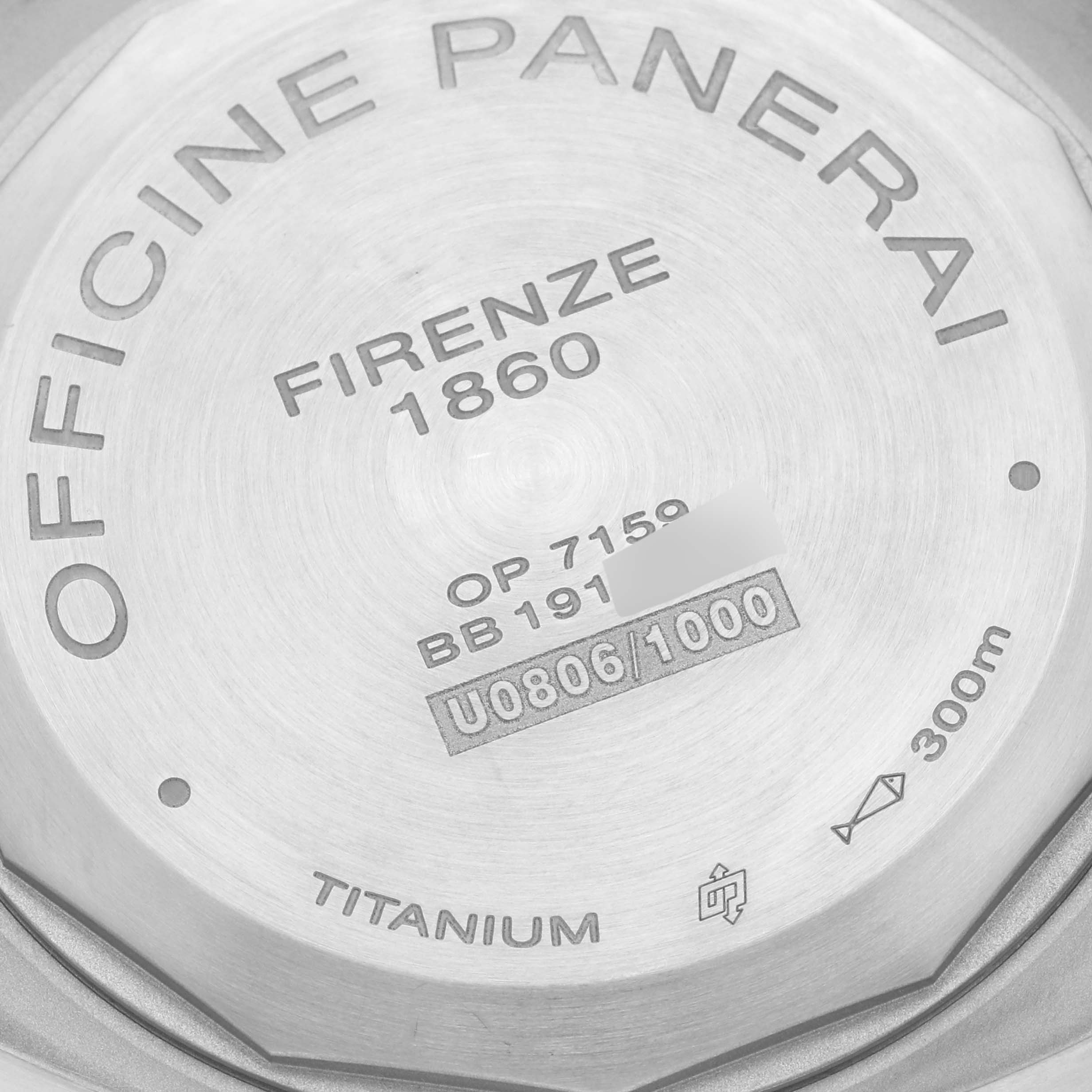 This image shows the titanium case back of a Luminor model by Panerai, featuring text and serial numbers.